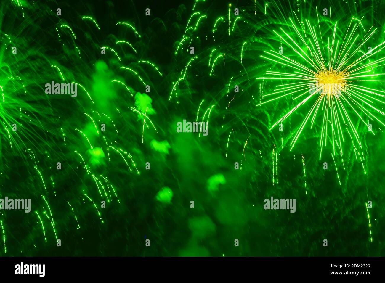 Vivid fireworks with glowing sparks in green colors. Explosive art, pyrotechnic devices. Holiday background Stock Photo