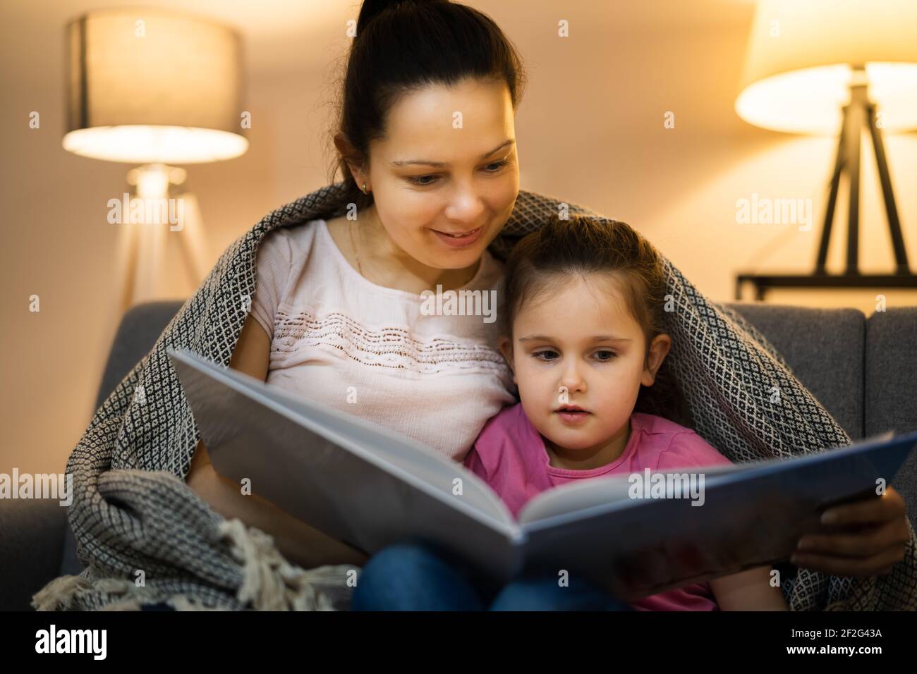 Bedtime Family Story In Evening At Home Stock Photo