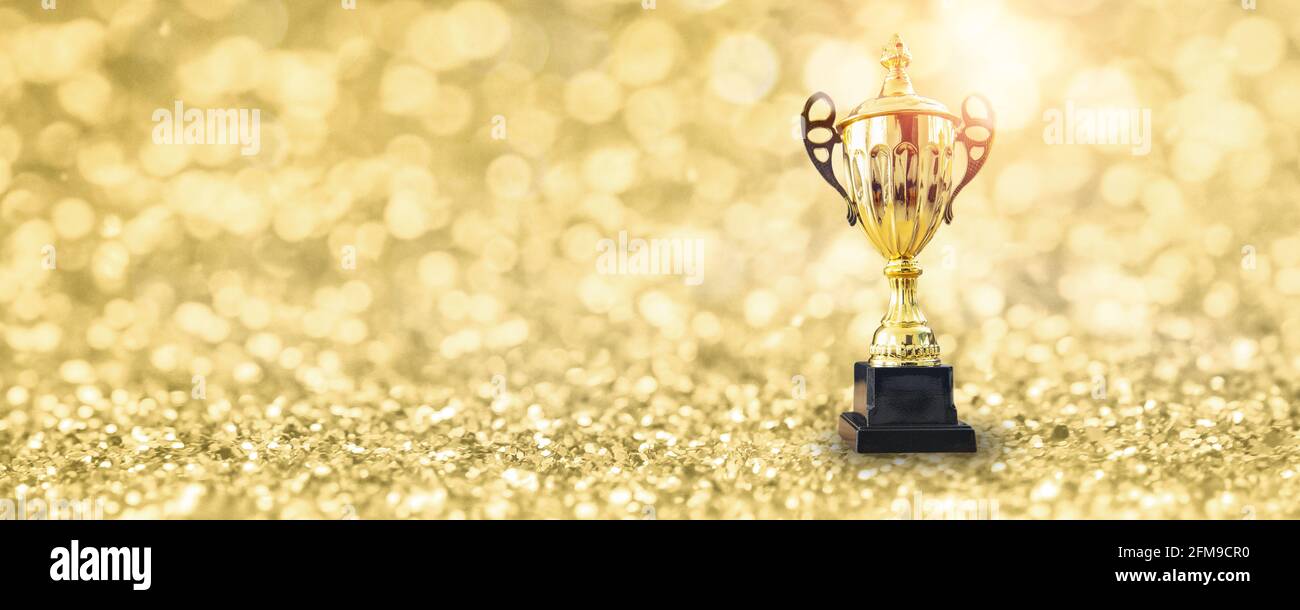 1st champion award, the best prize and winner concept, championship cup or winner trophy on golden floor with bokeh background Stock Photo