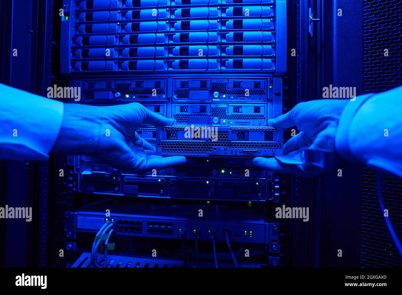 Busy system administrator examining work of supercomputer in server room Stock Photo