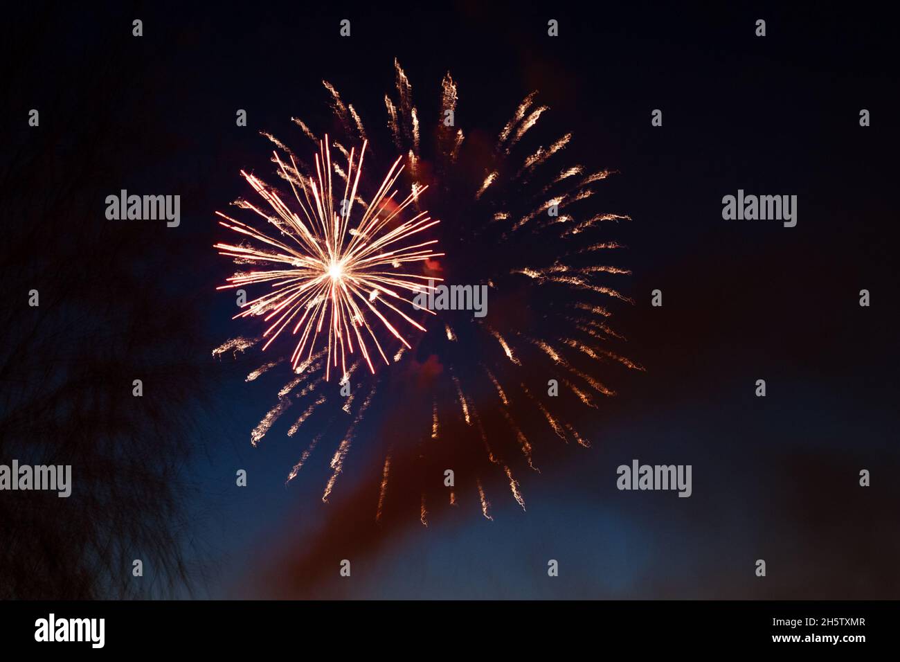 Sparks. Fireworks are class of explosive pyrotechnic devices used for aesthetic and entertainment purposes. Beautiful colorful fireworks sparkle in the night sky Stock Photo