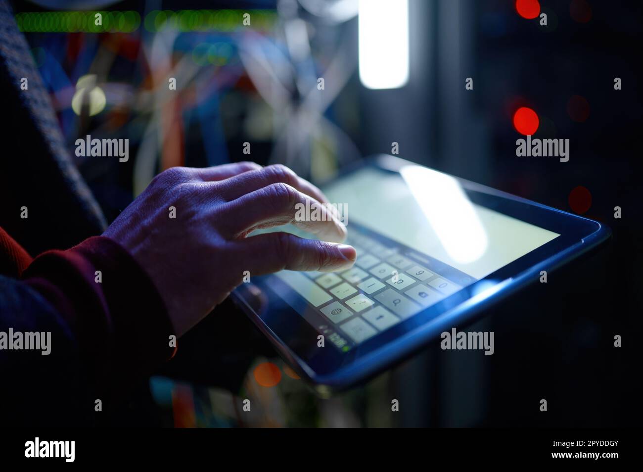 Closeup hand working in digital tablet in server room Stock Photo