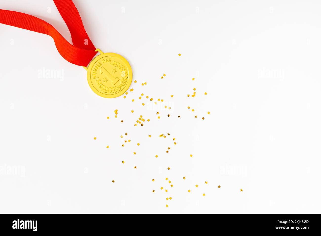 Golden medal on white background with golden glitter stars. Creative winner concept. Minimal victory backdrop idea. Flat lay. Stock Photo