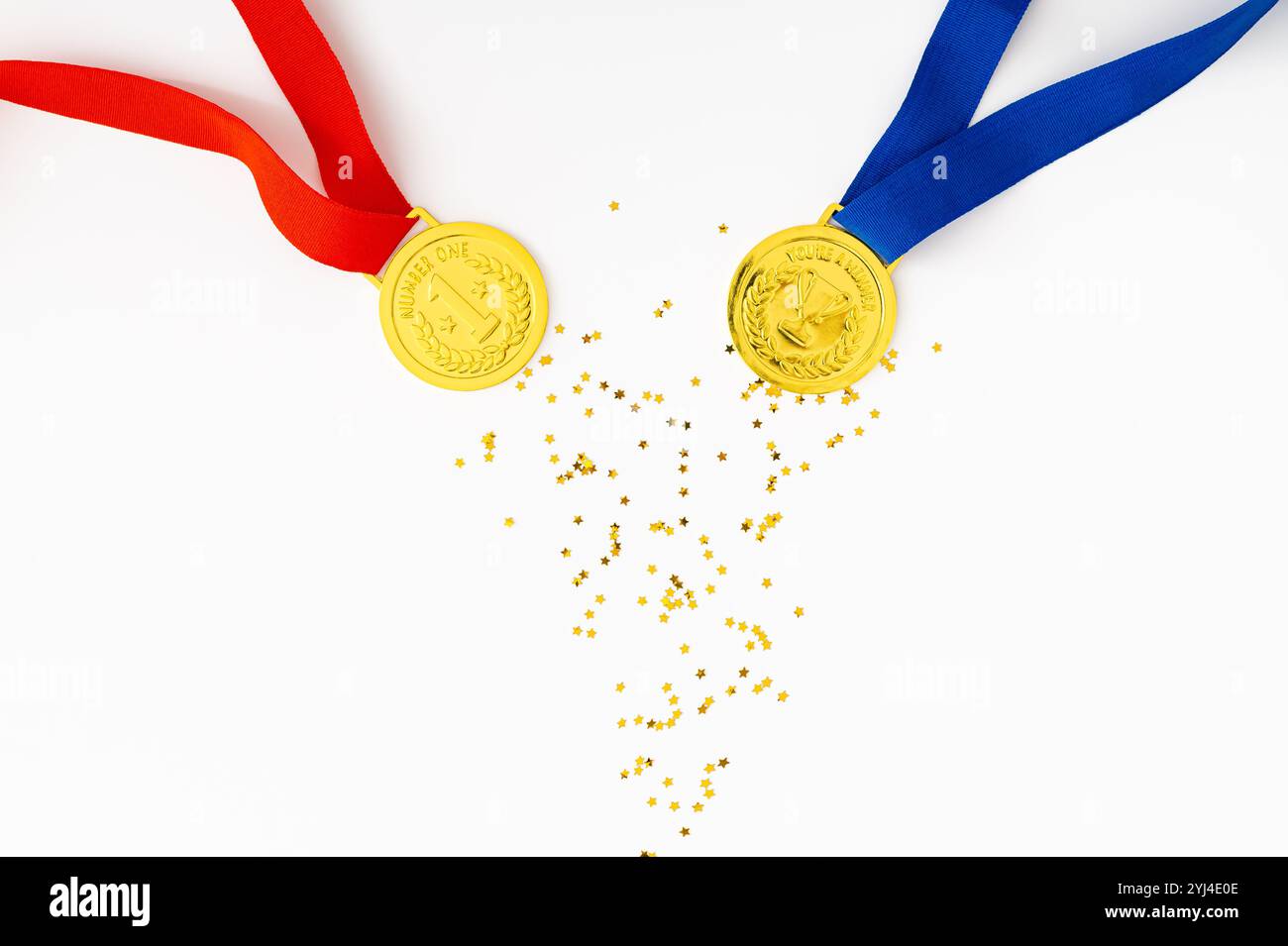 Golden medals on white background with golden glitter stars. Creative winner concept. Minimal victory backdrop idea. Flat lay. Stock Photo