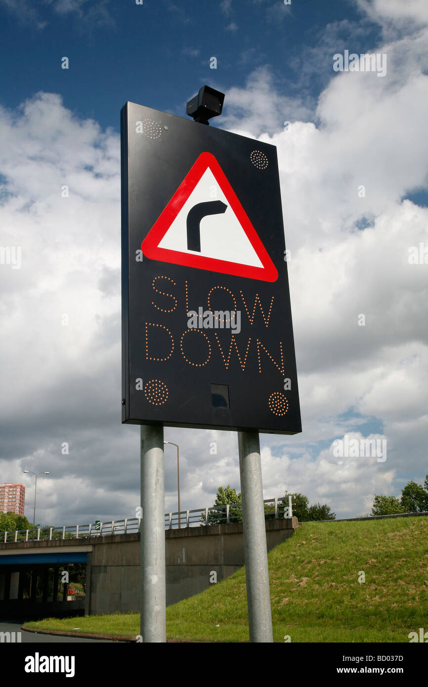 Slow Down road sign indicating a turn to the right Stock Photo