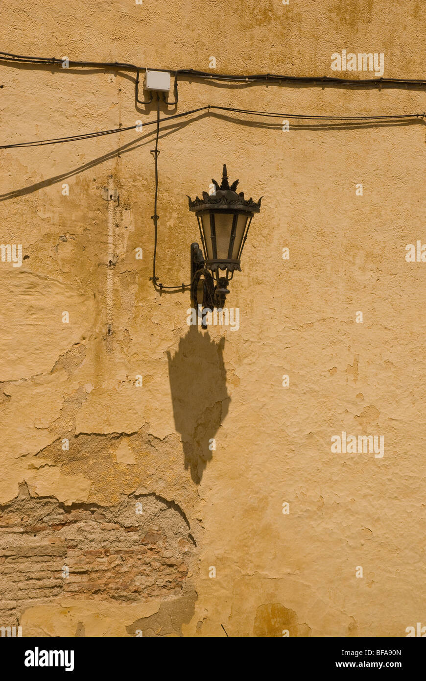 Street lamp fitted to crumbling wall Stock Photo