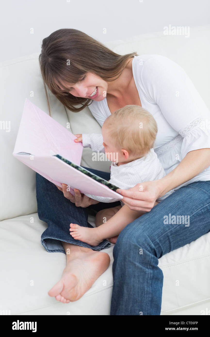 Baby holding a book with a mother Stock Photo