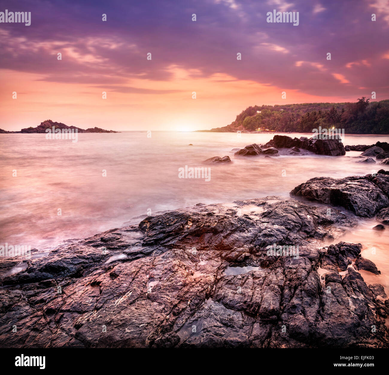 Sea with rocks at violet sunset sky in Om beach, Gokarna, Karnataka, India Stock Photo