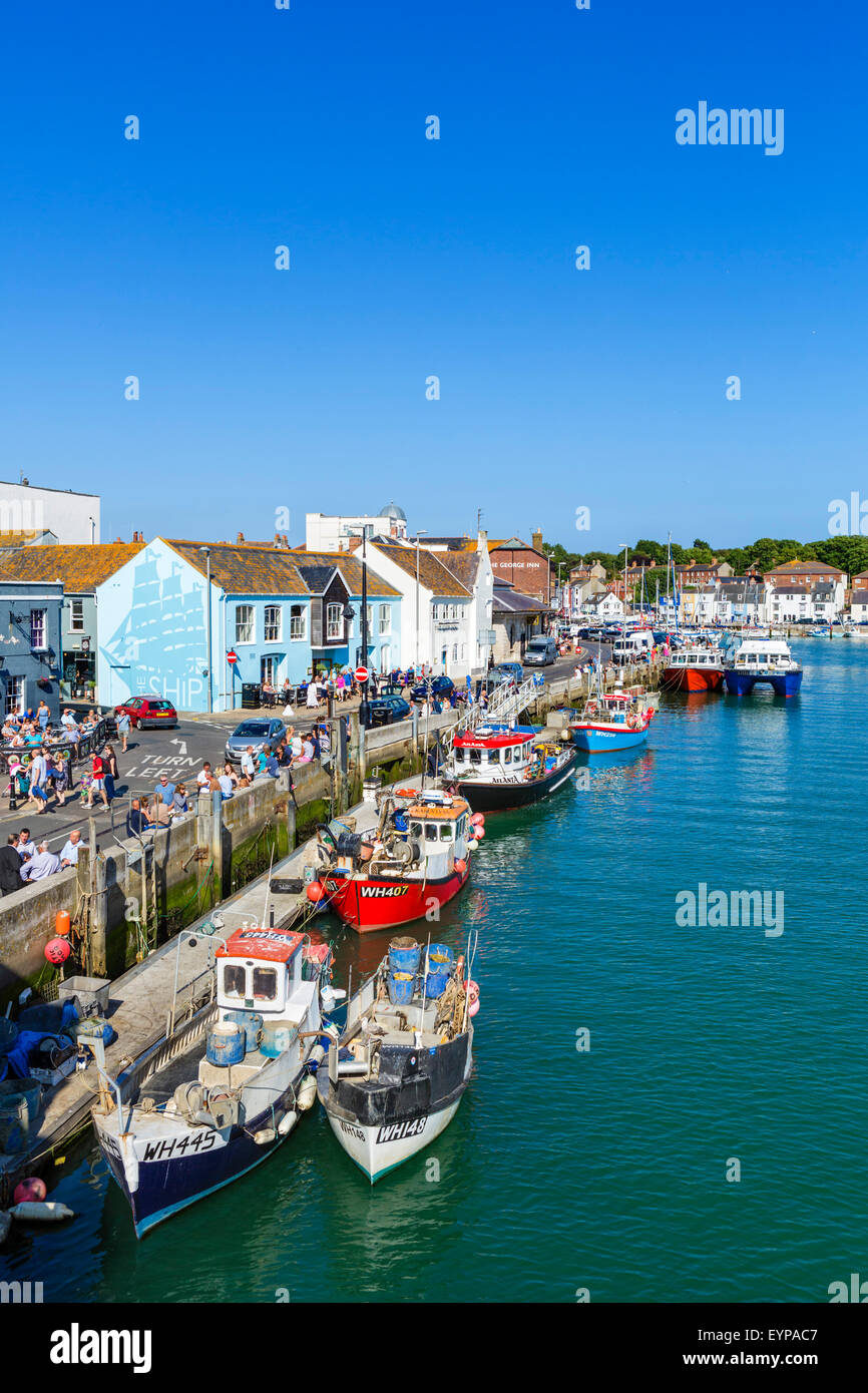 People sitting outside pubs and bars on Custom House Quay in Weymouth, Jurassic Coast, Dorset, England, UK Stock Photo