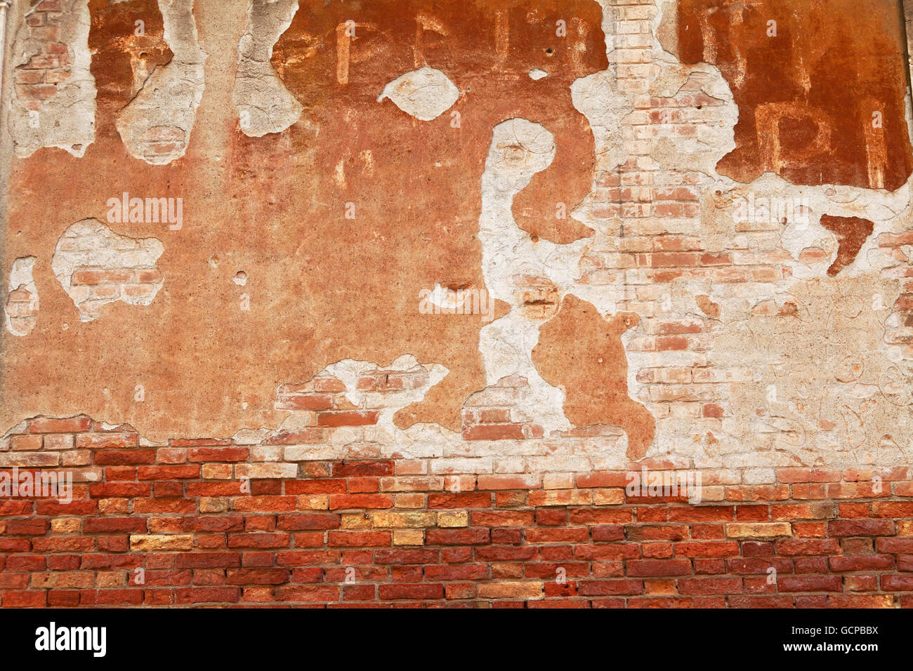 Decaying plaster on a city wall creates a threatening image. Stock Photo