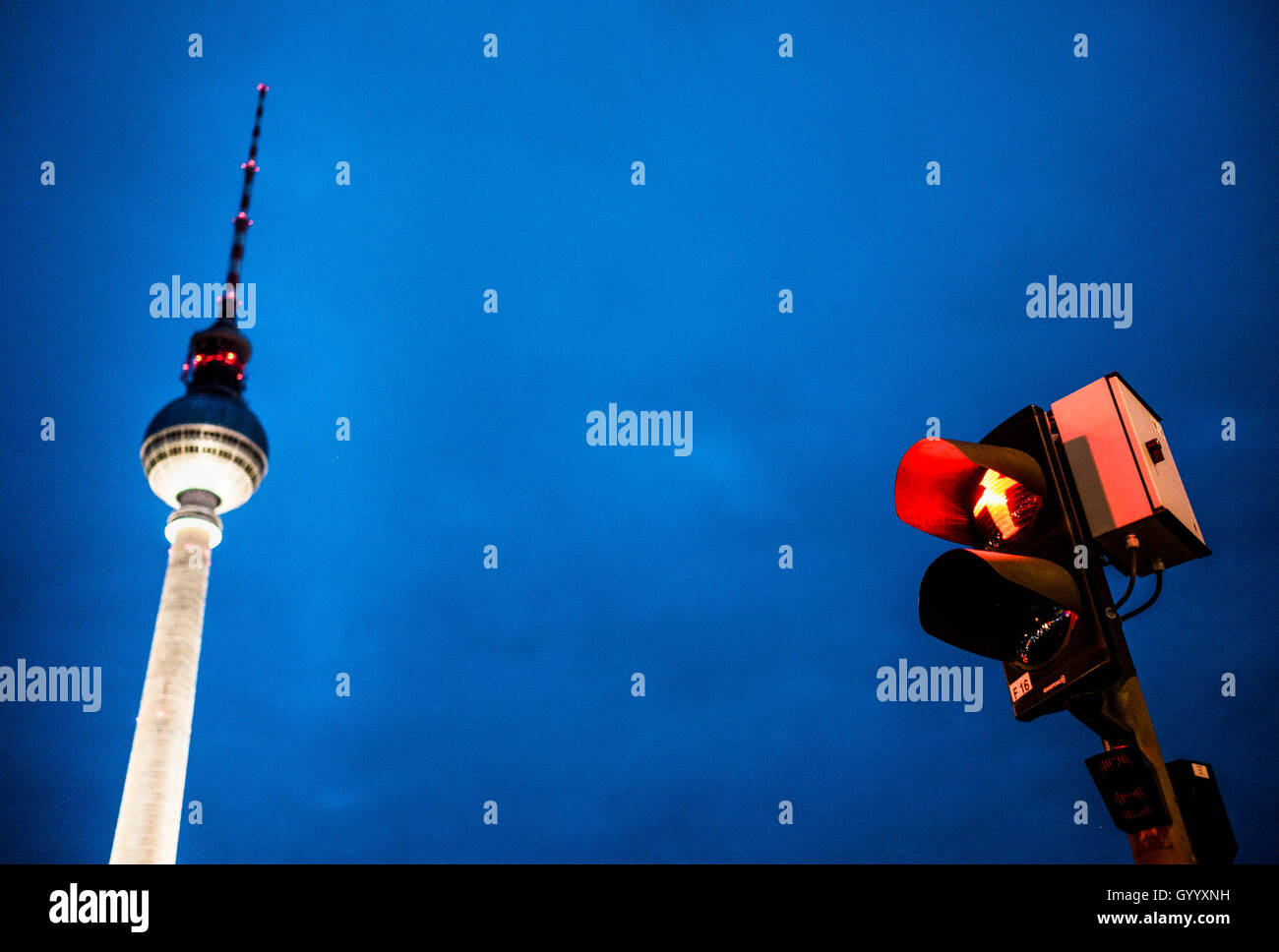 Red walking man figure, Ampelmännchen, at traffic light with television tower Alex at dusk, Alexanderplatz, Berlin, Germany Stock Photo