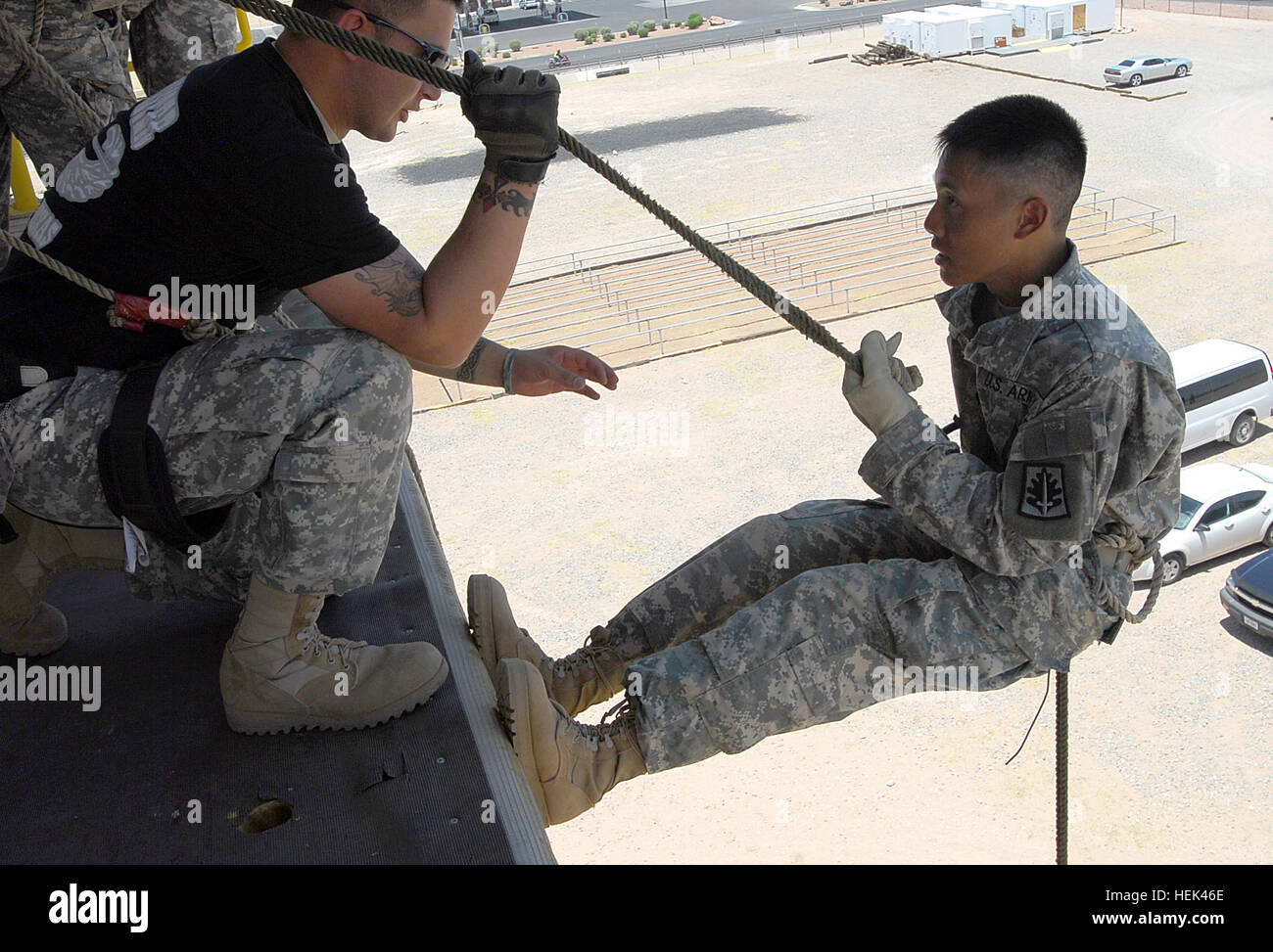 Air Assault Soldier of Headquarters and Headquarters Company, BSB, 5th Brigade Combat Team, 1st Armored Division, Spc. Caleb Zavala, coaches Spc. Ruifu Zhao as he rappels a tower at Fort Bliss, Texas, June 18. Zhao, a 310th MP Battalion Soldier, is participating in the Army Reserve 200th Military Police Command's Operation Guardian Justice, a combined Annual Training and Mobilization Training exercise at nearby Camp McGregor, N.M., involving about 1,000 Soldiers from across the country and Puerto Rico. Operation Guardian Justice 292968 Stock Photo