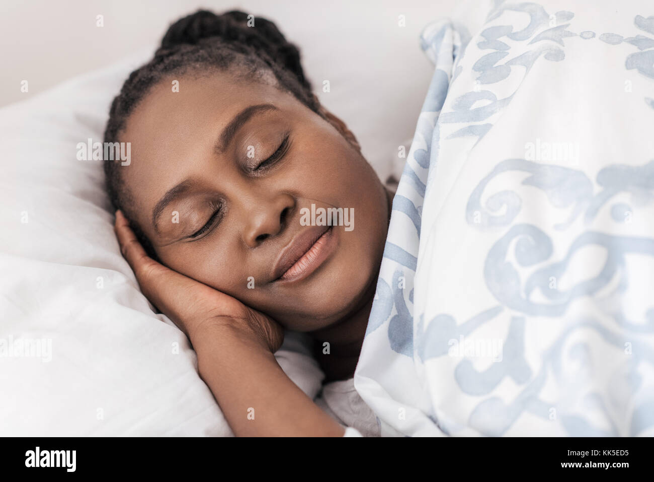 Young African woman sleeping in her bed at home Stock Photo