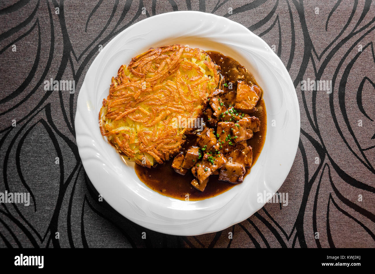 Zürcher Geschnetzeltes (sliced meat Zurich style) served with rösti. Stock Photo