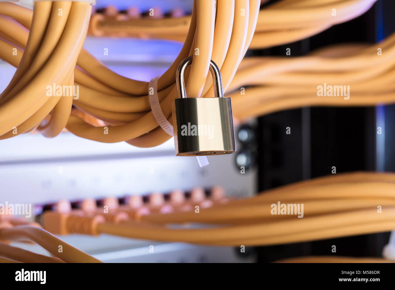 Closeup of padlock attached to network cable in server room Stock Photo