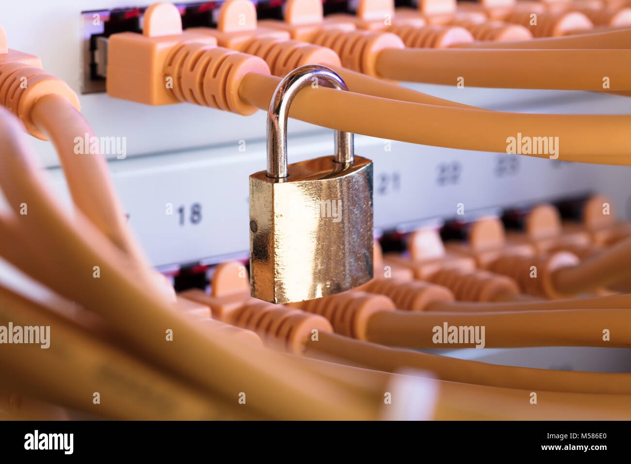 Closeup of padlock attached to network cable in server room Stock Photo