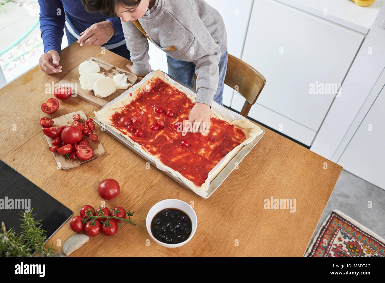 Grandmother and grandson making pizza in kitchen, elevated view Stock Photo