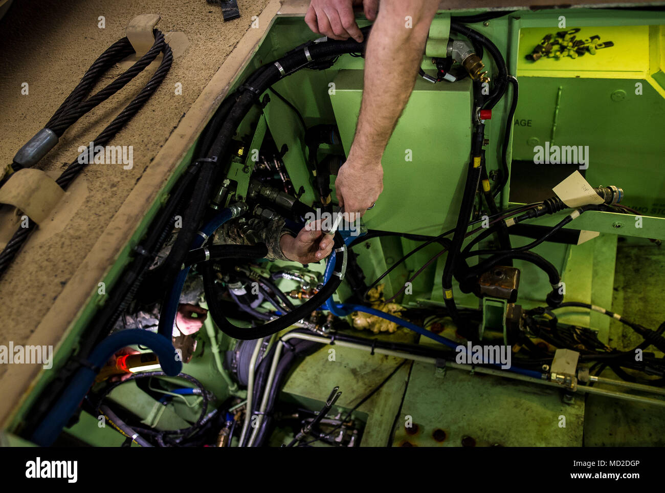 Two U.S. Army Reserve mechanics from within the 200th Military Police Command pass a mounting bracket to one another through the cramped space of an M117 Armored Security Vehicle (ASV) during a maintenance course hosted by the 99th Readiness Division in Schenectady, New York, March 13, 2018. This is the first maintenance course in the U.S. Army Reserve designed specifically for the ASV, which has hydraulic components and maintenance procedures that are unlike most other Army vehicles. The ASV is designed to resist the impact of roadside bombs while operating in urban environments. Its mounting Stock Photo