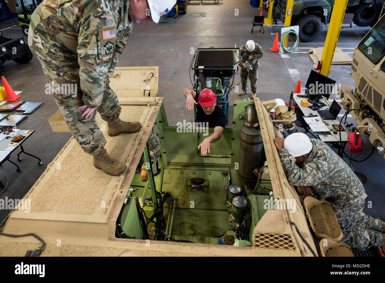 Herbert Green (center), maintenance instructor for the 99th Readiness Division, directs U.S. Army Reserve mechanics from the 200th Military Police Command how the engine pack will go back into an M1117 Armored Security Vehicle (ASV) during a maintenance course hosted in Schenectady, New York, March 14, 2018. This is the first maintenance course in the U.S. Army Reserve designed specifically for the ASV, which has hydraulic components and maintenance procedures that are unlike most other Army vehicles. The ASV is designed to resist the impact of roadside bombs while operating in urban environme Stock Photo