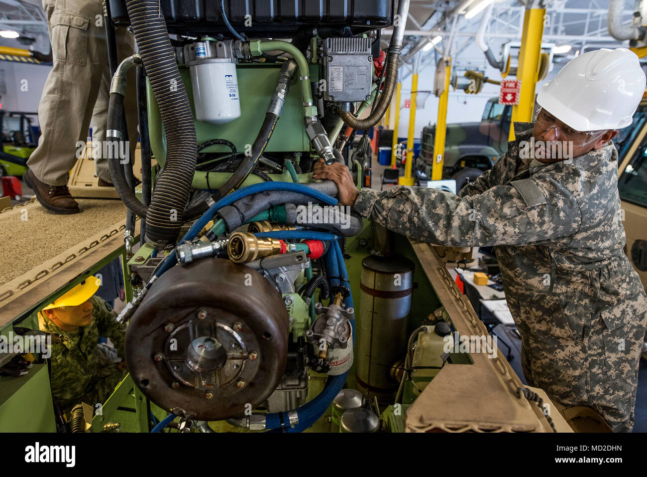 U.S. Army Reserve mechanics from across the 200th Military Police Command lower the engine pack into an M117 Armored Security Vehicle (ASV) during a maintenance course hosted by the 99th Readiness Division in Schenectady, New York, March 14, 2018. This is the first maintenance course in the U.S. Army Reserve designed specifically for the ASV, which has hydraulic components and maintenance procedures that are unlike most other Army vehicles. The ASV is designed to resist the impact of roadside bombs while operating in urban environments. Its mounting systems allow the ASV to hold an M2 .50-cali Stock Photo