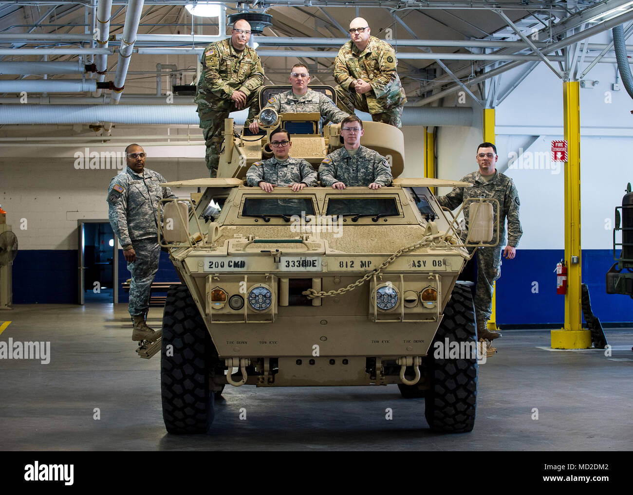 U.S. Army Reserve mechanics from across the 200th Military Police Command pose for a group photo on an M117 Armored Security Vehicle (ASV) during a maintenance course hosted by the 99th Readiness Division in Schenectady, New York, March 14, 2018. This is the first maintenance course in the U.S. Army Reserve designed specifically for the ASV, which has hydraulic components and maintenance procedures that are unlike most other Army vehicles. The ASV is designed to resist the impact of roadside bombs while operating in urban environments. Its mounting systems allow the ASV to hold an M2 .50-calib Stock Photo