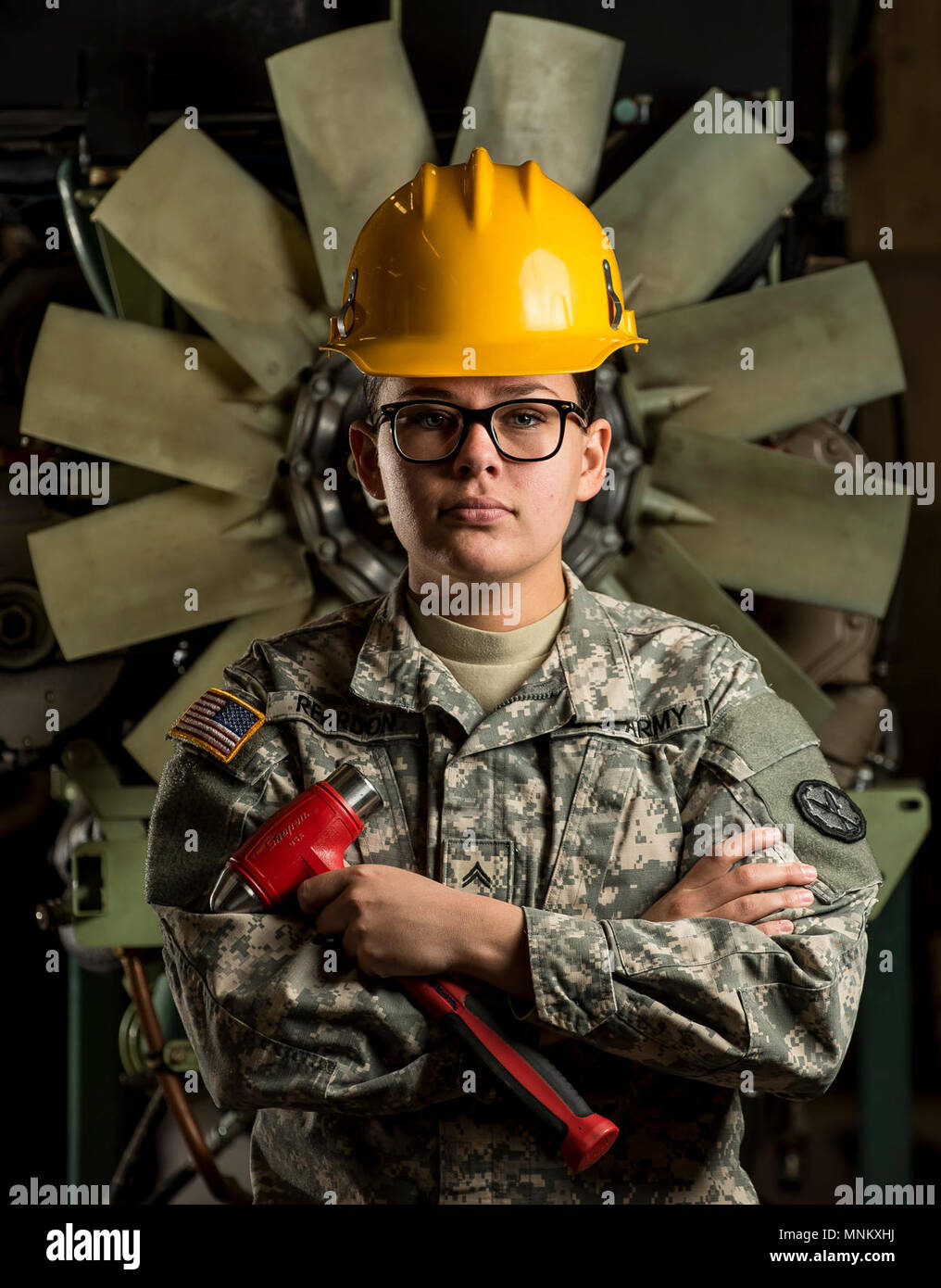 Cpl. Cala Reardon, a U.S. Army Reserve mechanic with the 377th Military Police Company (Combat Support), out of Cincinnati, Ohio, poses for a portrait in front of an M117 Armored Security Vehicle (ASV) engine during a maintenance course hosted by the 99th Readiness Division in Schenectady, New York, March 14, 2018. This is the first maintenance course in the U.S. Army Reserve designed specifically for the ASV, which has hydraulic components and maintenance procedures that are unlike most other Army vehicles. The ASV is designed to resist the impact of roadside bombs while operating in urban en Stock Photo