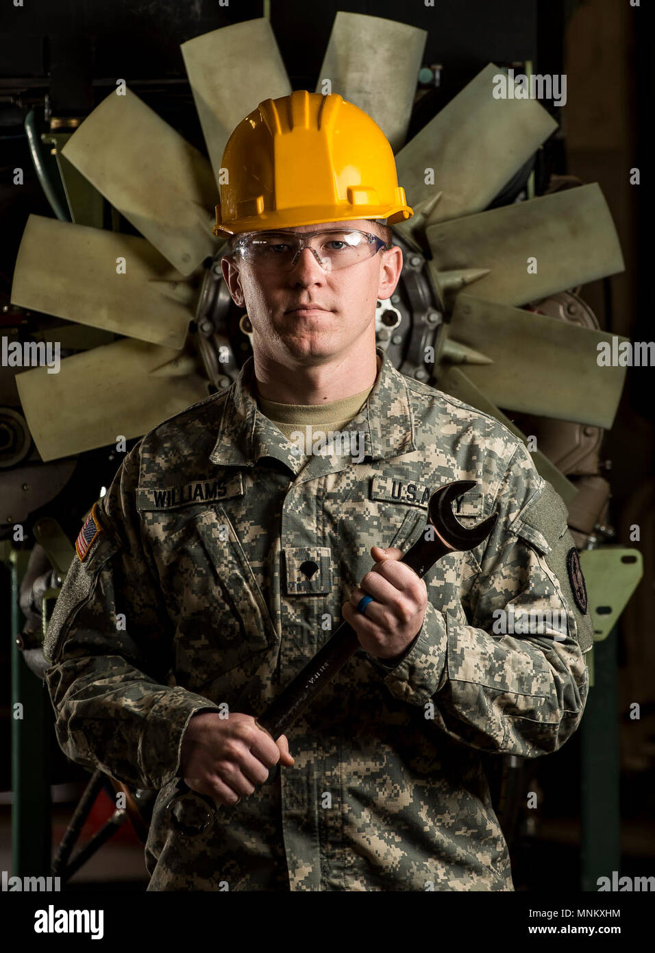 Spc. John Williams, a U.S. Army Reserve mechanic with the 346th Military Police Company (Combat Support) poses for a portrait in front of an M117 Armored Security Vehicle (ASV) engine during a maintenance chourse hosted by the 99th Readiness Division in Schenectady, New York, March 14, 2018. This is the first maintenance course in the U.S. Army Reserve designed specifically for the ASV, which has hydraulic components and maintenance procedures that are unlike most other Army vehicles. The ASV is designed to resist the impact of roadside bombs while operating in urban environments. Its mounting Stock Photo