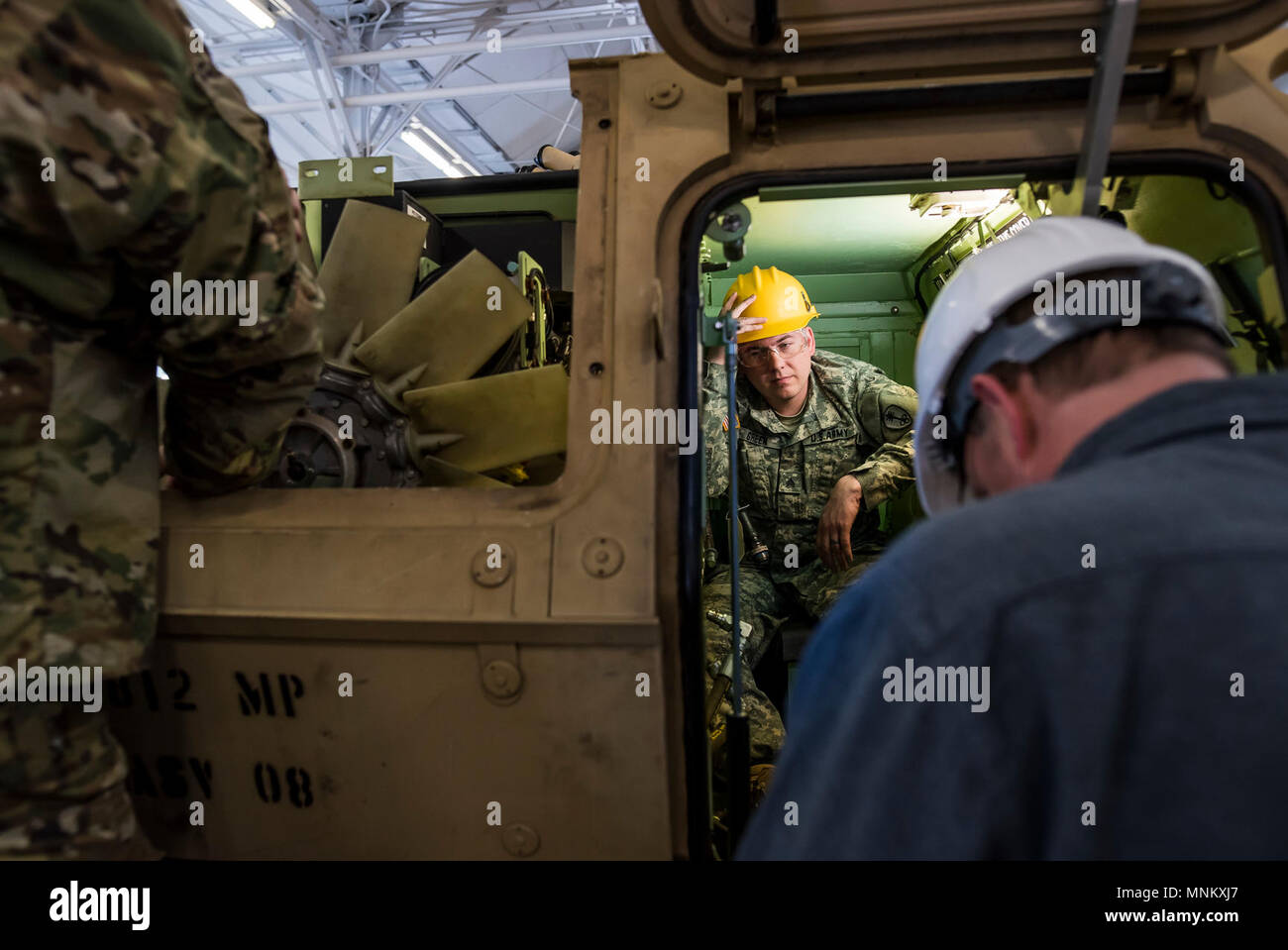 Sgt. Thomas Green, a U.S. Army Reserve mechanic with the 447th Military Police Company (Combat Support), out of North Canton, Ohio, takes a brief rest while working inside a small storage space of an M117 Armored Security Vehicle (ASV) during a maintenance course hosted by the 99th Readiness Division in Schenectady, New York, March 14, 2018. This is the first maintenance course in the U.S. Army Reserve designed specifically for the ASV, which has hydraulic components and maintenance procedures that are unlike most other Army vehicles. The ASV is designed to resist the impact of roadside bombs  Stock Photo