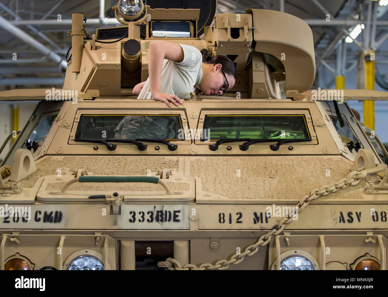 Cpl. Cala Reardon, a U.S. Army Reserve mechanic with the 377th Military Police Company (Combat Support), out of Cincinnati, Ohio, climbs through one of the front hatches of an M117 Armored Security Vehicle (ASV) while working on the vehicle during a maintenance course hosted by the 99th Readiness Division in Schenectady, New York, March 13, 2018. This is the first maintenance course in the U.S. Army Reserve designed specifically for the ASV, which has hydraulic components and maintenance procedures that are unlike most other Army vehicles. The ASV is designed to resist the impact of roadside b Stock Photo