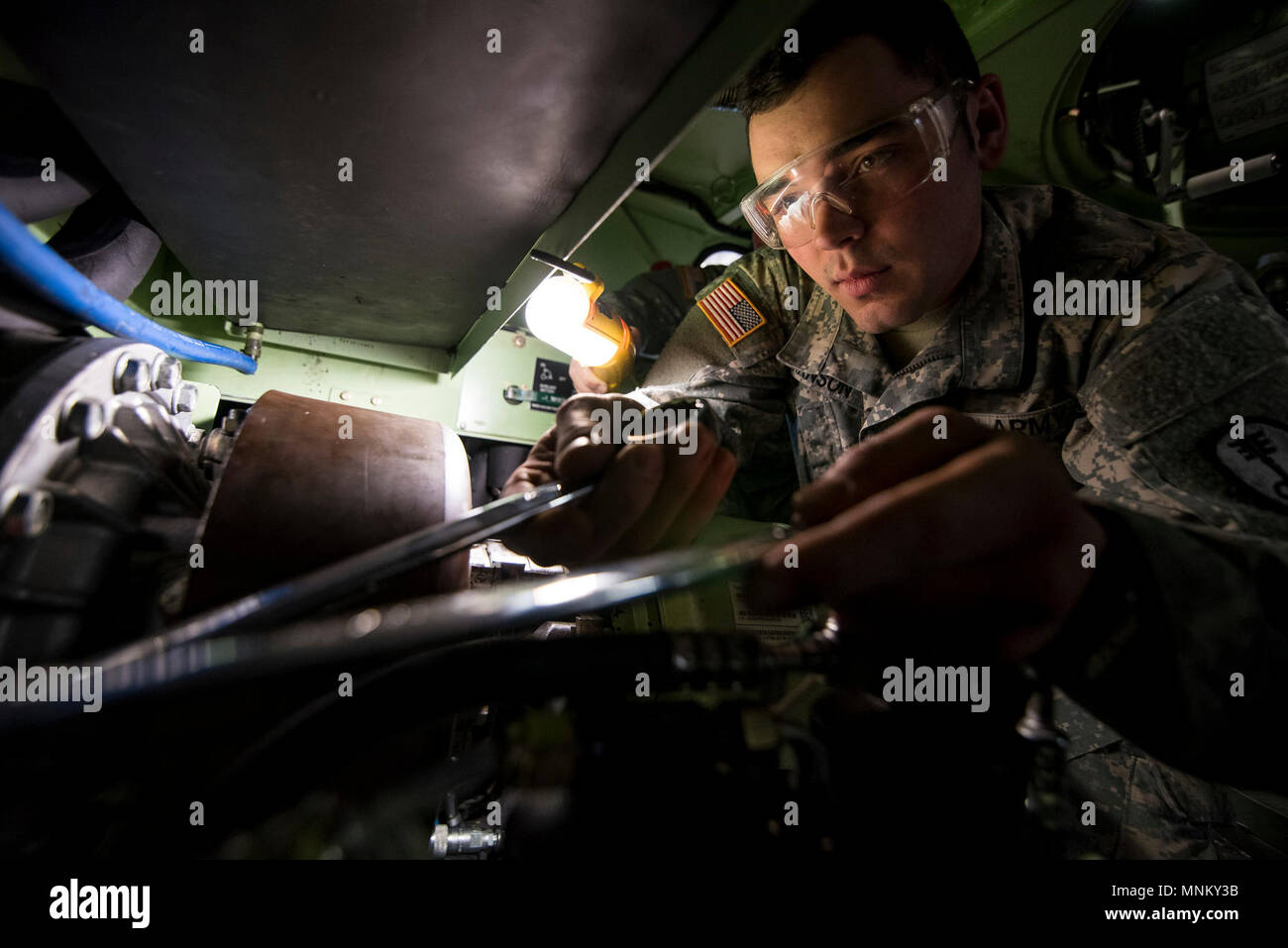 Spc. Wyatt Hanson, a U.S. Army Reserve mechanic with the 342nd Military Police Company (Combat Support), out of Columbus, Ohio, works inside the tight space of an M117 Armored Security Vehicle (ASV) during a maintenance course hosted by the 99th Readiness Division in Schenectady, New York, March 14, 2018. This is the first maintenance course in the U.S. Army Reserve designed specifically for the ASV, which has hydraulic components and maintenance procedures that are unlike most other Army vehicles. The ASV is designed to resist the impact of roadside bombs while operating in urban environments Stock Photo