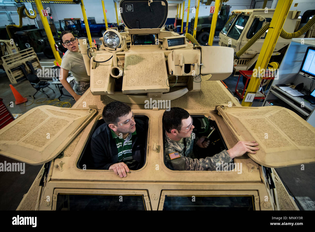 Spc. Wyatt Hanson (right), a U.S. Army Reserve mechanic with the 342nd Military Police Company (Combat Support), out of Columbus, Ohio, tests the driver's hatch of an M117 Armored Security Vehicle (ASV) during a maintenance course hosted by the 99th Readiness Division in Schenectady, New York, March 14, 2018. This is the first maintenance course in the U.S. Army Reserve designed specifically for the ASV, which has hydraulic components and maintenance procedures that are unlike most other Army vehicles. The ASV is designed to resist the impact of roadside bombs while operating in urban environm Stock Photo