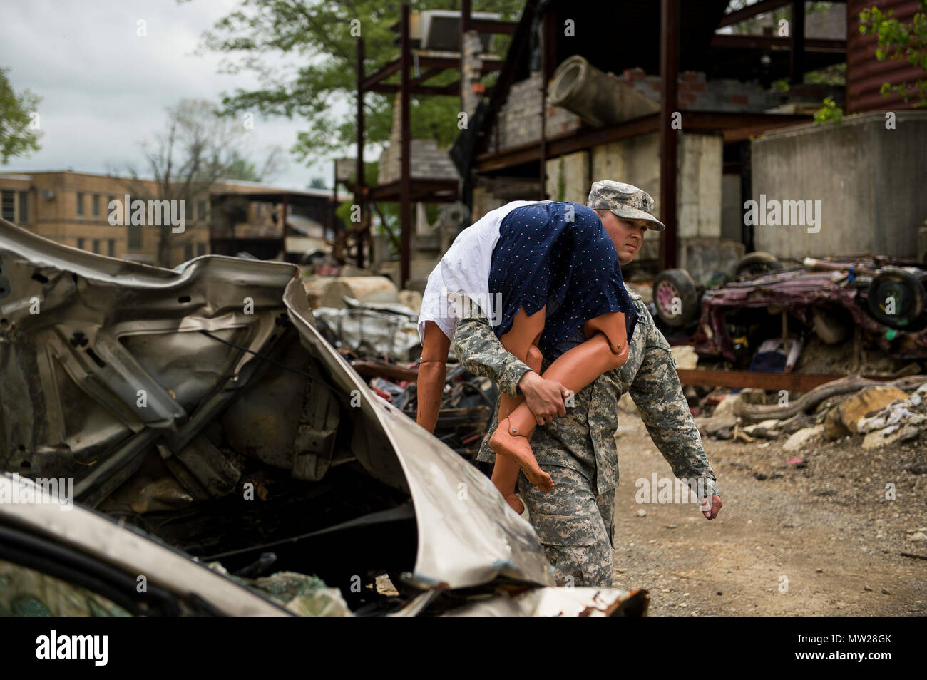 Sgt. 1st Class John Hawes, a U.S. Army Reserve Soldier supporting the 78th Training Division, carries a medical mannequin for a casualty collection point during Guardian Response 17 at the Muscatatuck Urban Training Center, Indiana, April 27, 2017. Guardian Response, as part of Vibrant Response, is a multi-component training exercise run by the U.S. Army Reserve designed to validate nearly 4,000 service members in Defense Support of Civil Authorities (DSCA) in the event of a Chemical, Biological, Radiological and Nuclear (CBRN) catastrophe. This year's exercise simulated an improvised nuclear  Stock Photo