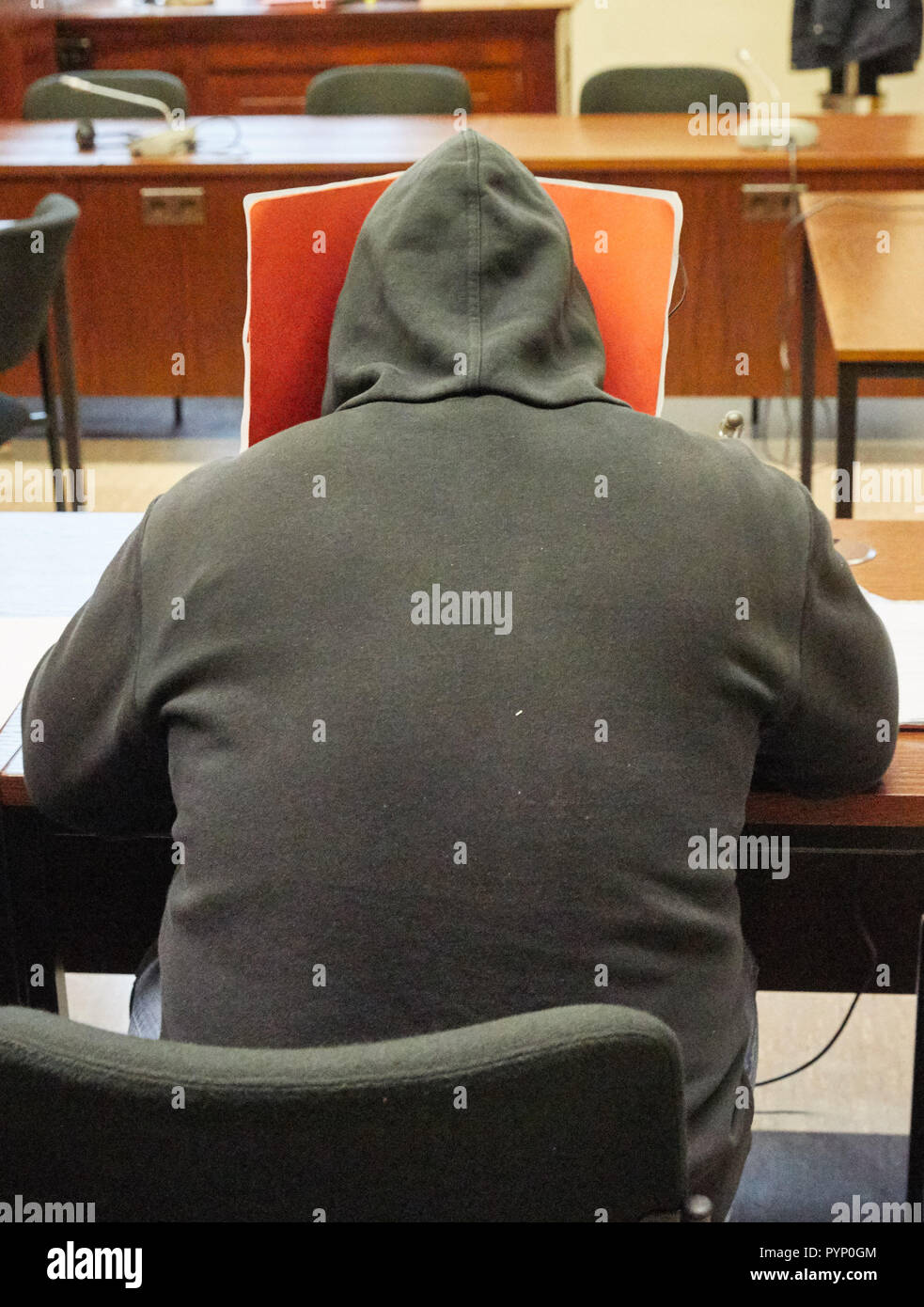 Hamburg, Germany. 29th Oct, 2018. The defendant sitting in a courtroom of the criminal justice building before the sentence is pronounced. The 52-year-old is accused of having ignited a plastic bag with two pyrotechnic explosive devices and mounting screws on a platform. The charges include attempted murder, causing an explosives explosion, and dangerous bodily injury. Credit: Georg Wendt/dpa/Alamy Live News Stock Photo