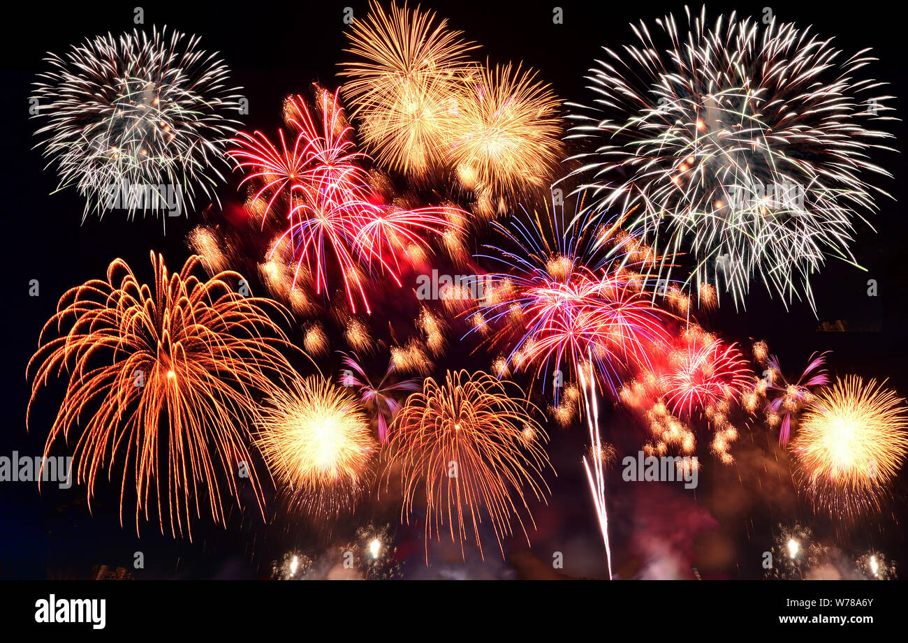 Colorful fireworks. Fireworks are a class of explosive pyrotechnic devices used for aesthetic and entertainment purposes. Visible noise due to low lig Stock Photo