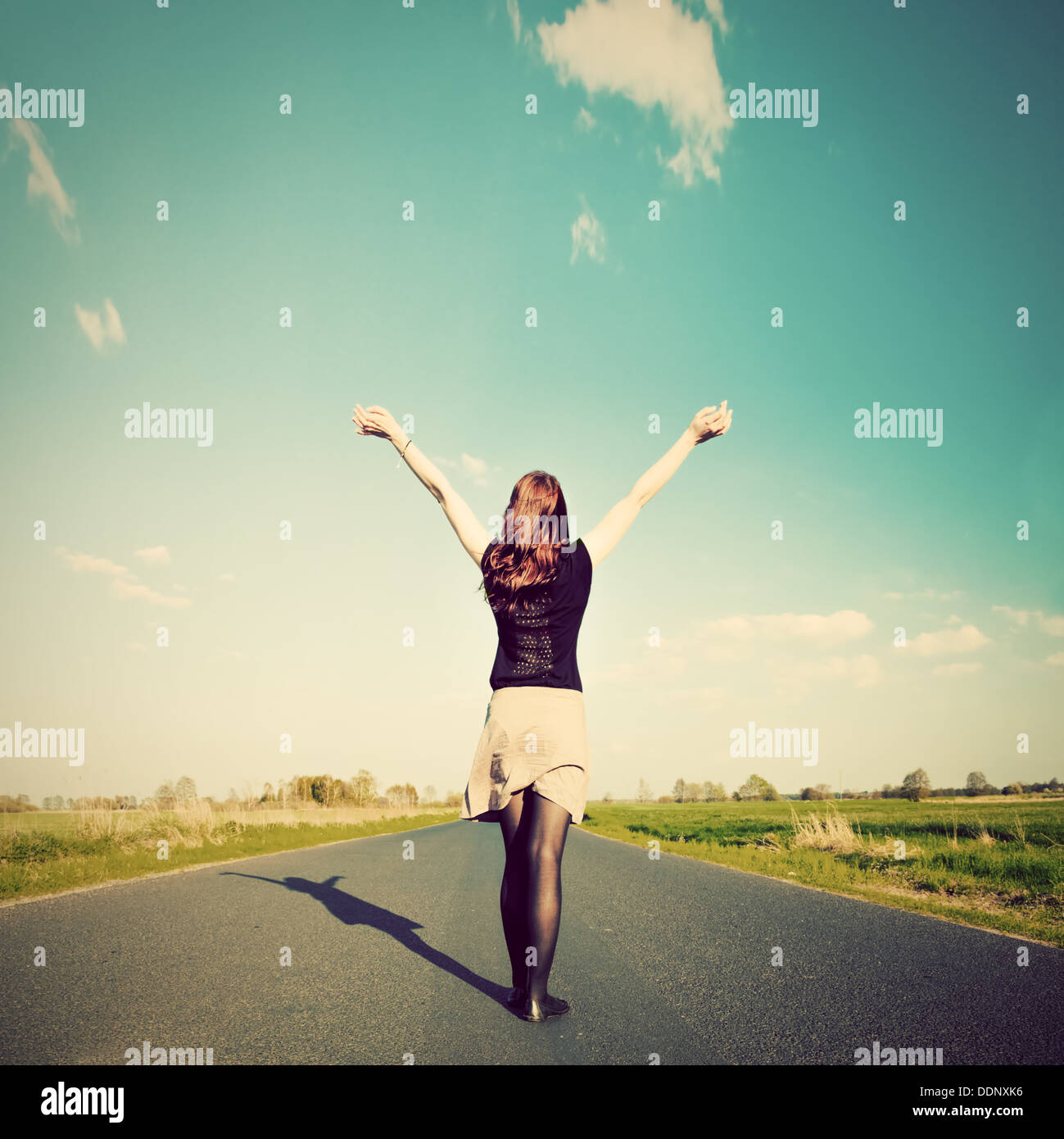 Glückliche Frau mit Händen stehend auf gerader Straße Sonne zugewandt. Zukunft / Freiheit / hoffe / Erfolgskonzept Stockfoto