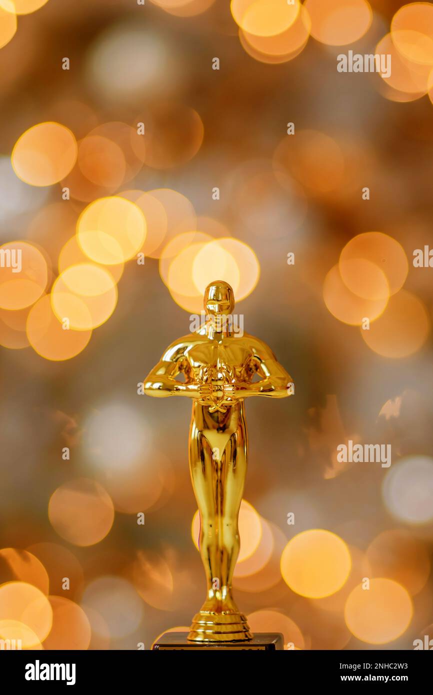 Hollywood Gold oscars trophée figurine imitation vue lors d'une cérémonie de cinéma de récompense. Le concept de réussite et de victoire affiche une statuette en jaune scintillant Banque D'Images