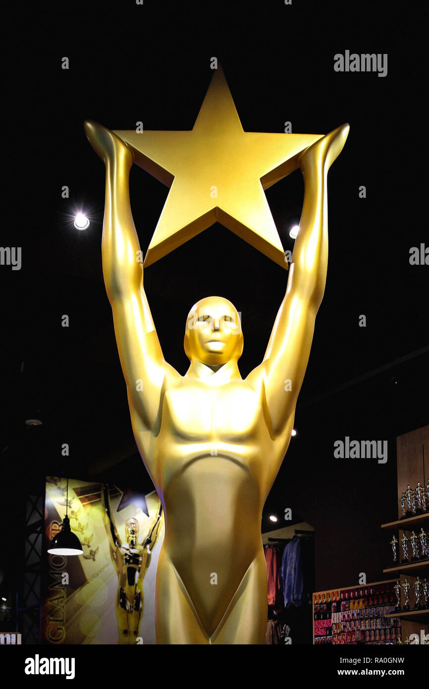 Hollywood, CA/ USA - Juillet 26, 2018 : Oscar d'or Statue holding gold star. Golden Award ou trophée est symbole de réussite et de Victoire concept Banque D'Images