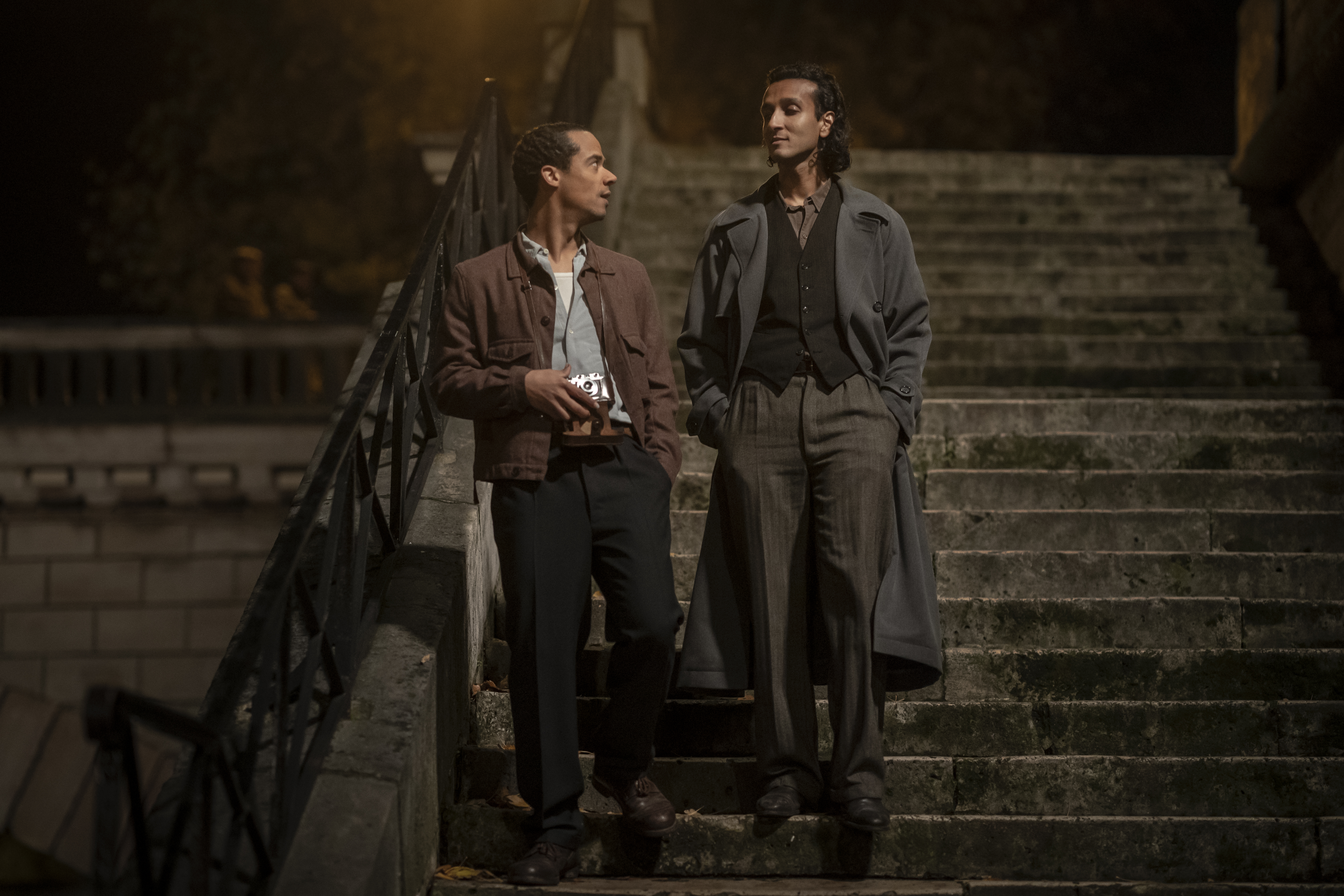 Two men descend a staircase in a park.