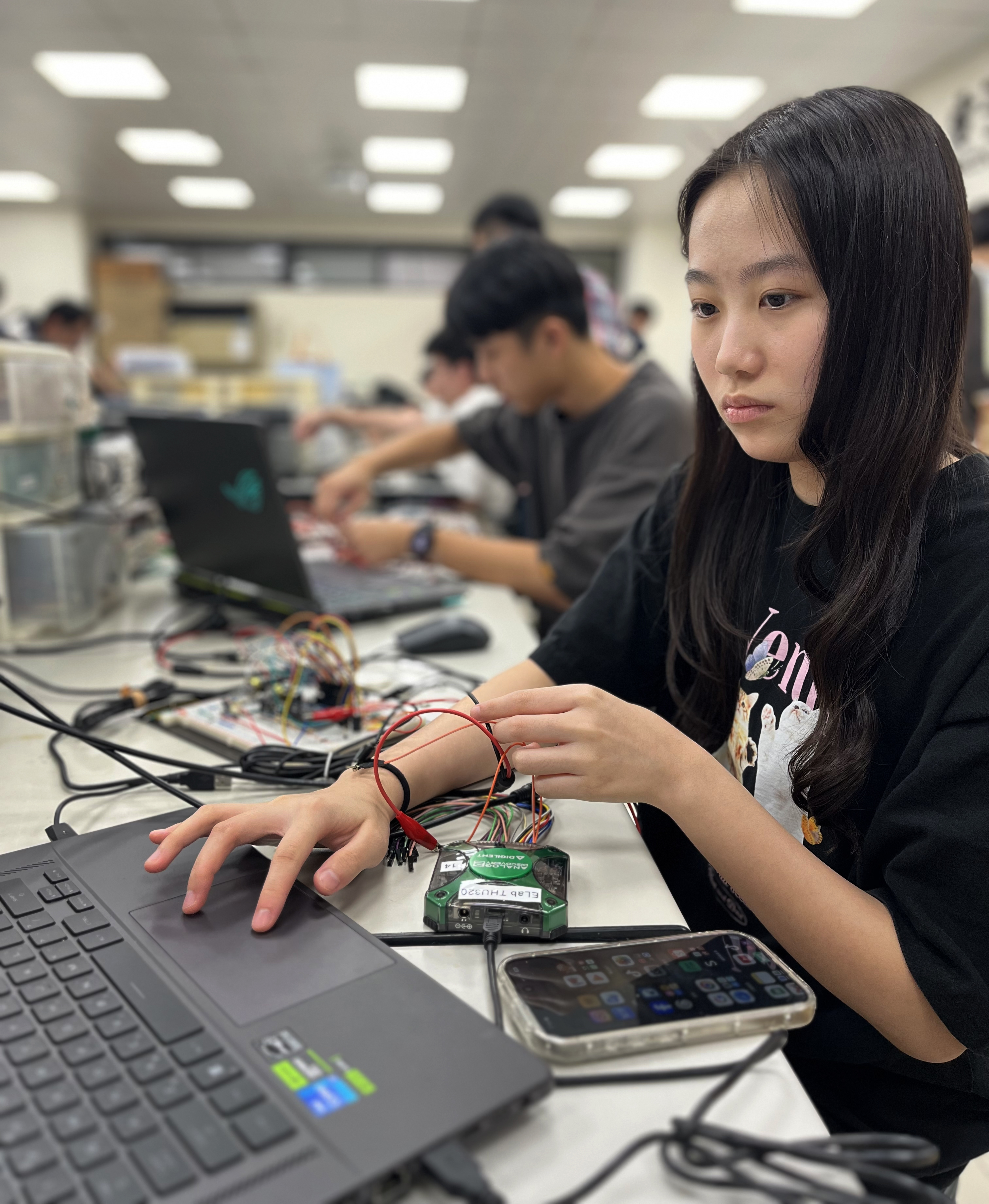 Wei Yu-han, 19, works on her final project in the electronics engineering lab at NYCU (Stephanie Yang / Los Angeles Times)
