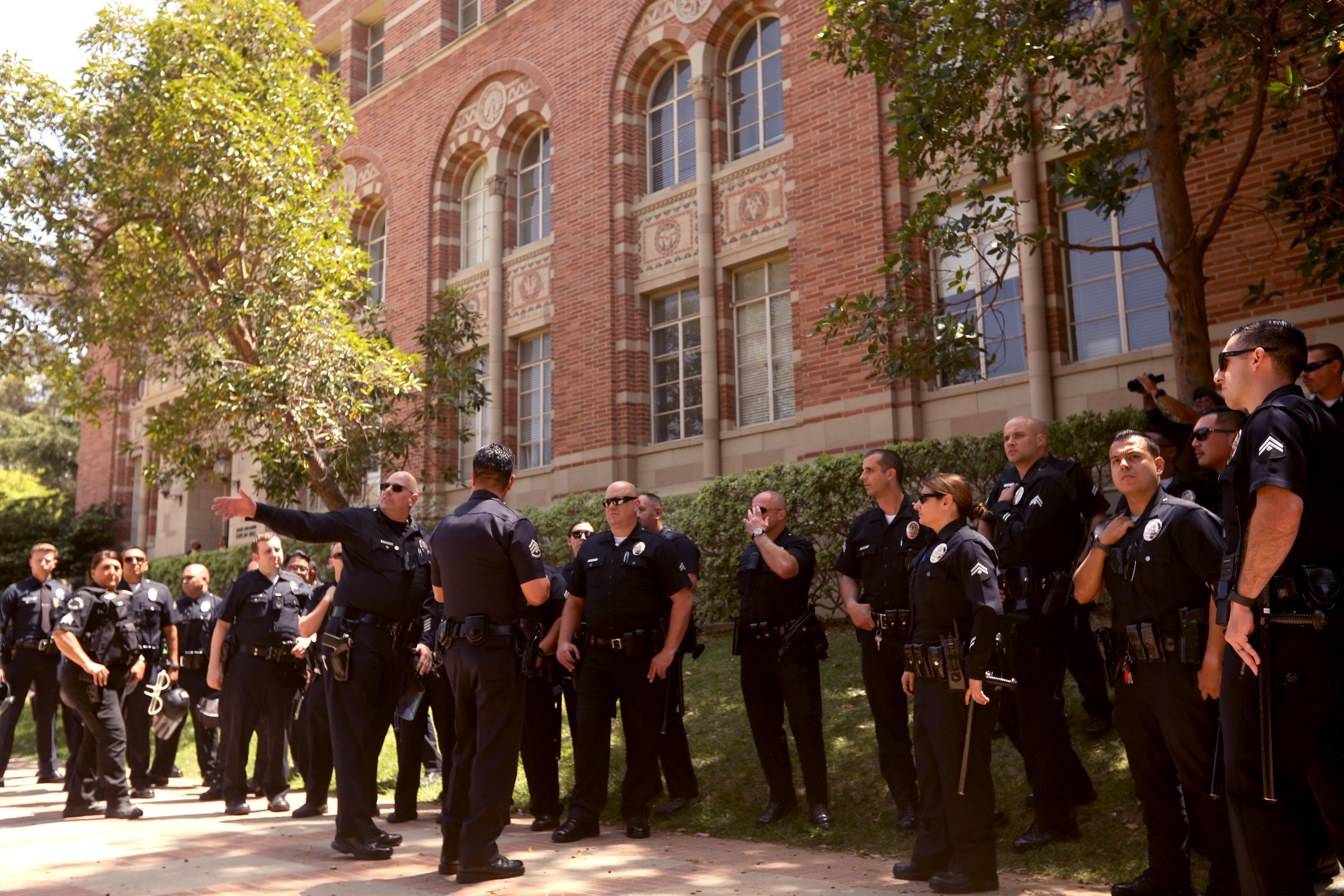 LOS ANGELES, CA - MAY 1, 2024 - Campus police confer while posting yards away from the pro-Palestinian camp on the UCLA campus on May 1, 2024. (Genaro Molina/Los Angeles Times)