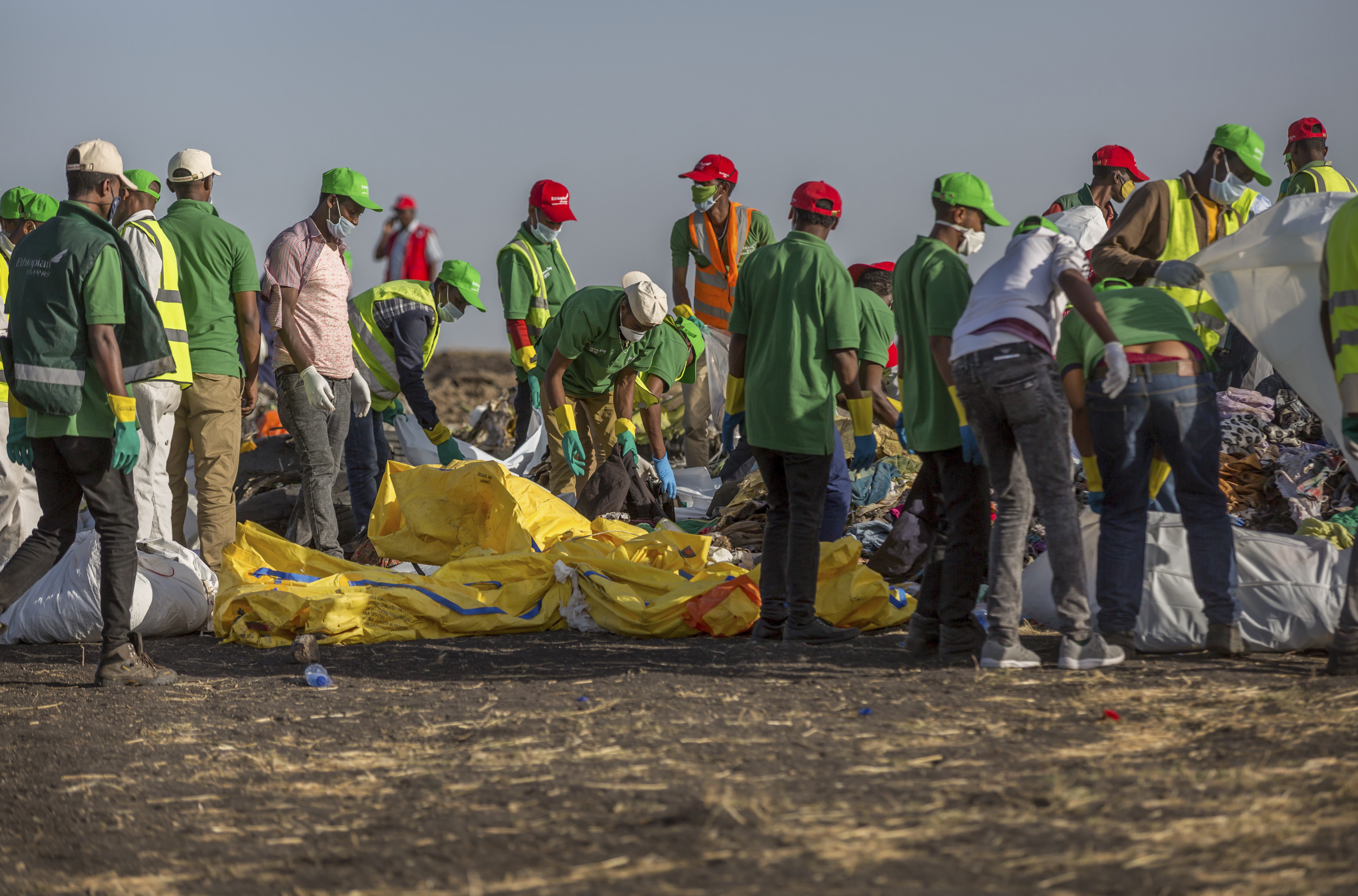 FILE - Workers collect debris on March 12, 2019 at the scene where an Ethiopian Airlines Boeing 737 Max 8 crashed shortly after takeoff, killing all 157 on board, near Bishoftu, or Debre Zeit, south of Addis Ababa, in Ethiopia. On Sunday, July 7, 2024, the Justice Department said Boeing has agreed to plead guilty to a criminal fraud charge stemming from two deadly crashes of 737 Max jetliners. (AP Photo/Mulugeta Ayene, File)