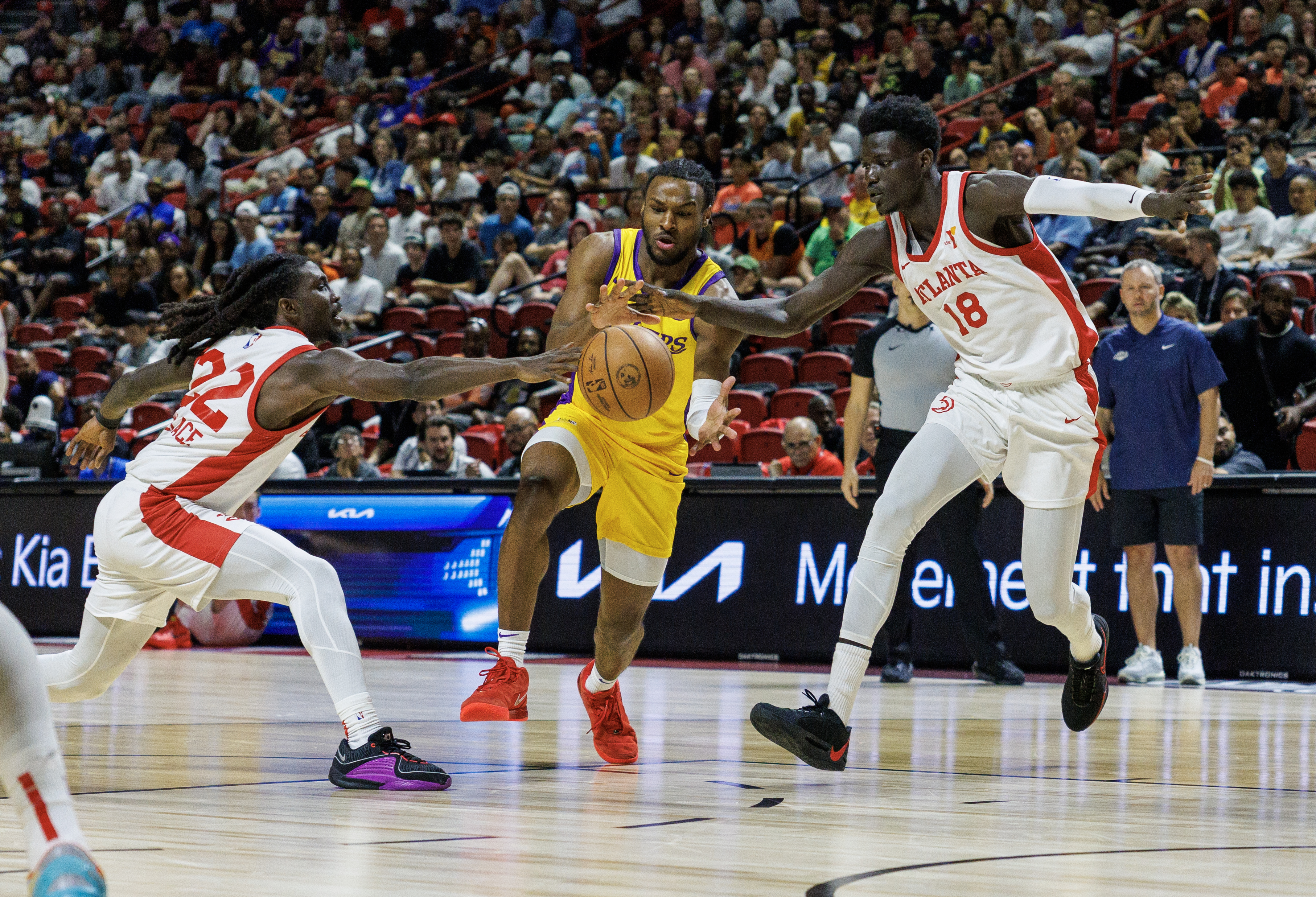 LAS VEGAS, NV - JULY 17, 2024: Los Angeles Lakers guard Bronny James (9) drives through the defense of Atlanta Hawks guard Keaton Wallace (22) and Atlanta Hawks forward Mouhamed Gueye (18) during the first half of the NBA 2K25 Summer League at the Thomas & Mack Center on July 17, 2024 in Las Vegas, Nevada.(Gina Ferazzi / Los Angeles Times)