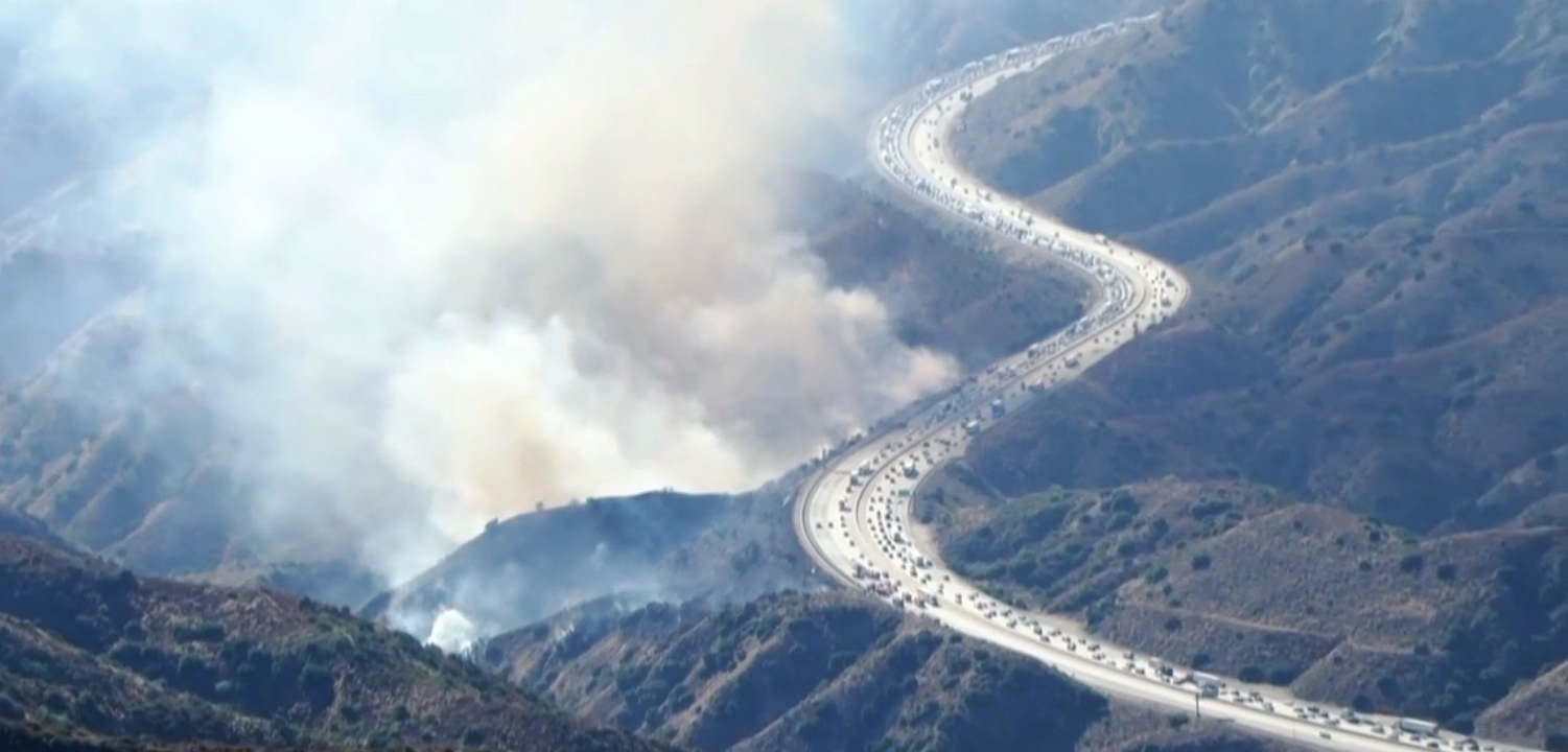 View of the smoke from the brush fire burning off the side of I-210 near Tujunga
