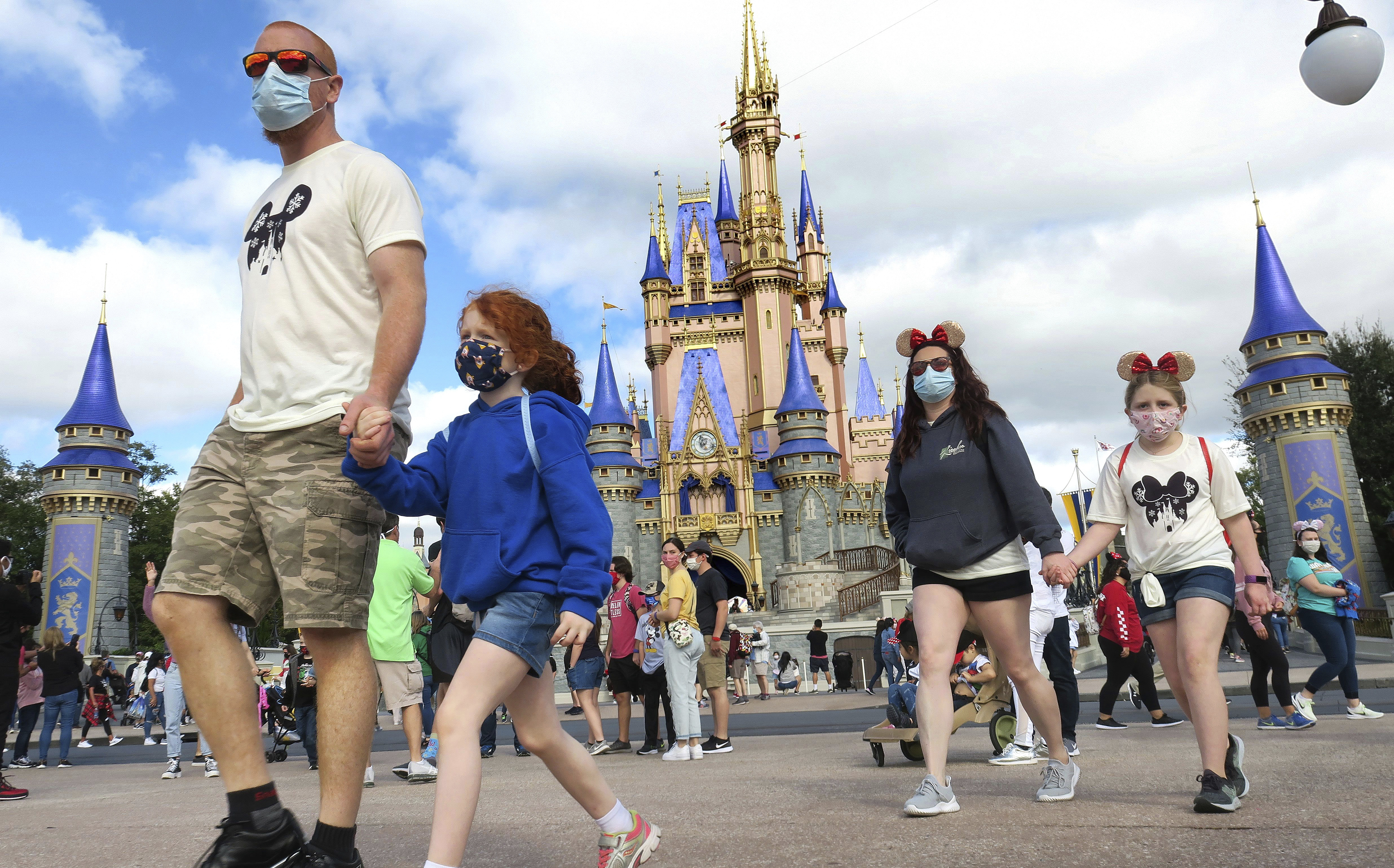 A family walks past the castle at Walt Disney World.