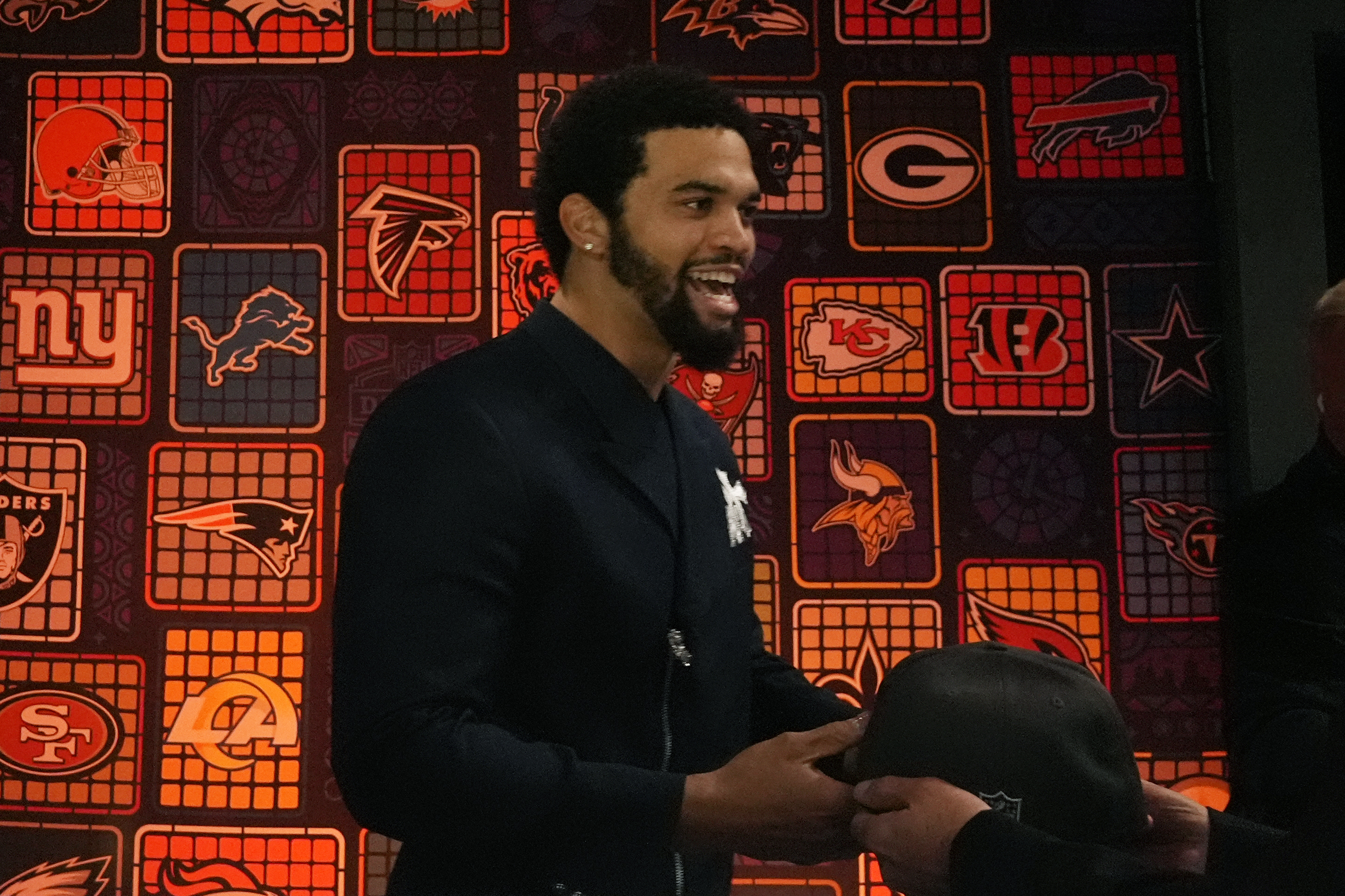 Caleb Williams takes a hat after being chosen by the Chicago Bears with the first pick of the NFL draft.