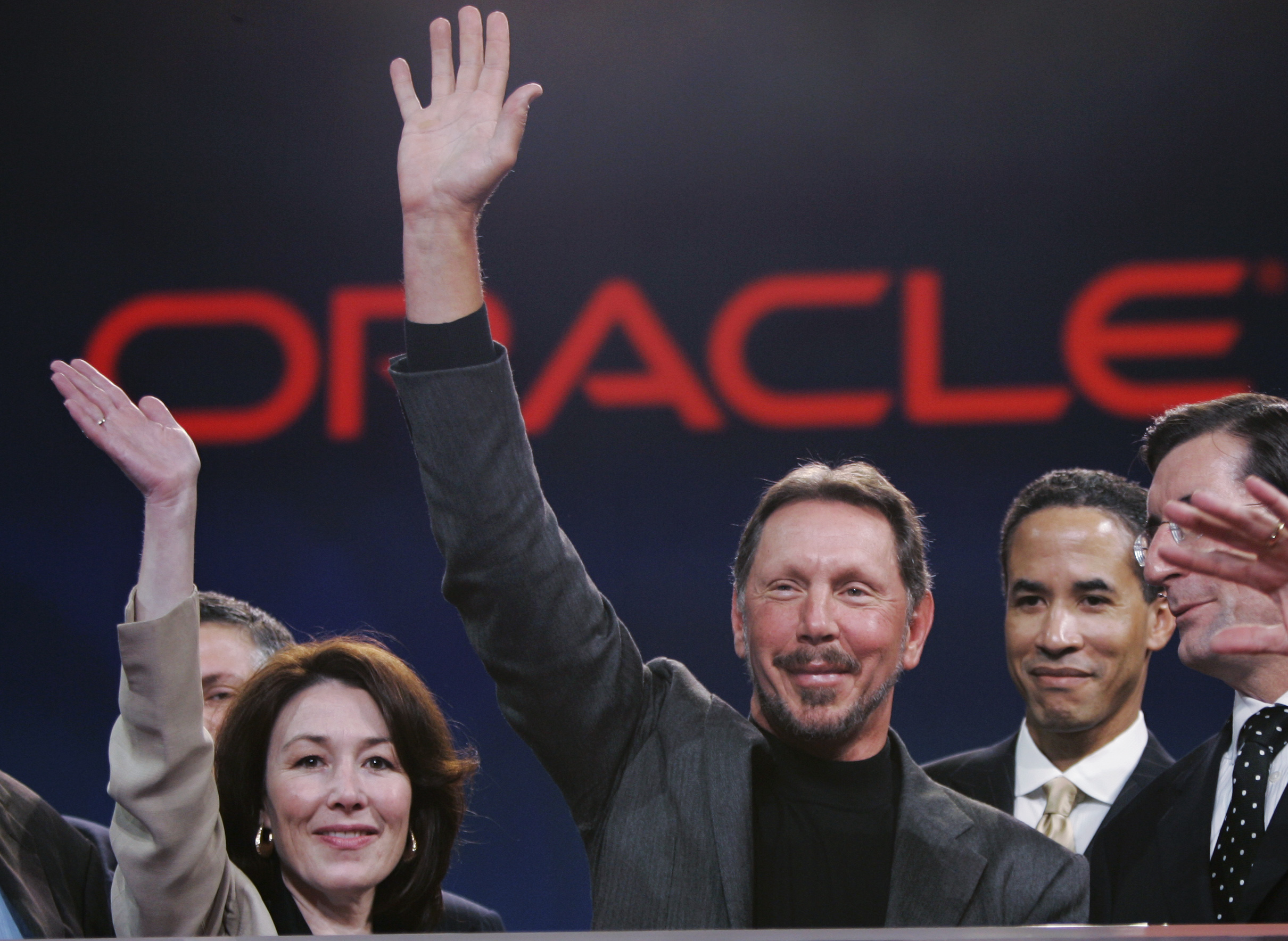 Oracle CEO Larry Ellison, center, smiles with Oracle CFO Safra Catz, left, and Oracle president Charles Phillips, second from right, during the Oracle Open World conference in San Francisco, Wednesday, Oct. 25, 2006. Oracle Corp. is scheduled to report fiscal second-quarter earnings after the bell. (AP Photo/Paul Sakuma)