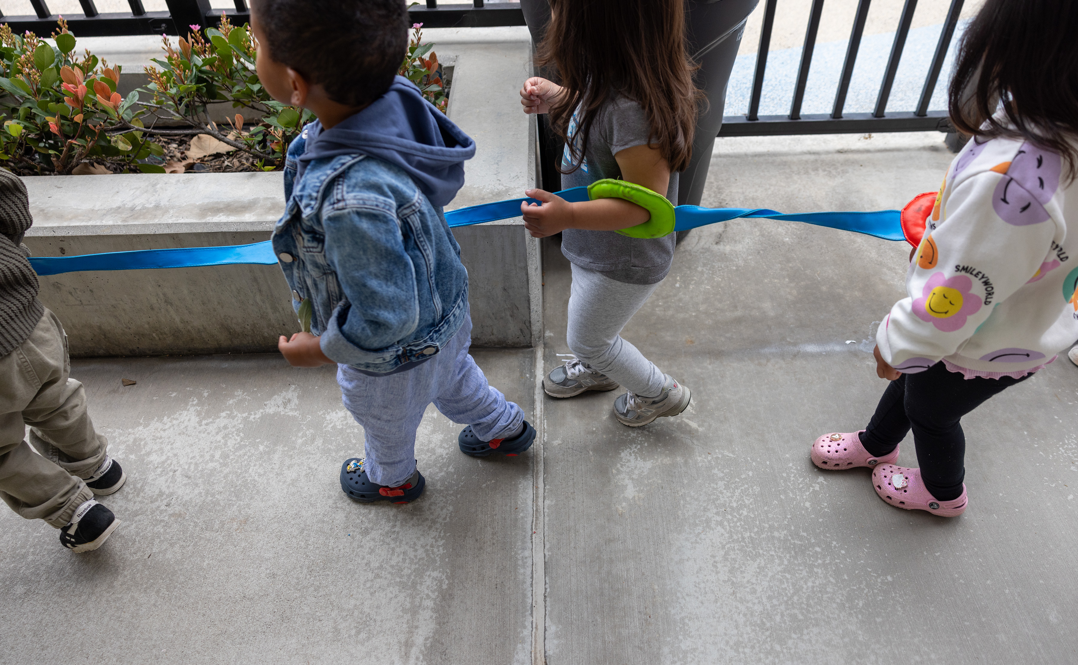 Long Beach, CA - March 20: Toddlers are strung together on their way to recess at Educare Los Angeles at Long Beach, a very high-quality child care center in Long Beach on Wednesday, March 20, 2024 in Long Beach, CA. (Brian van der Brug / Los Angeles Times)