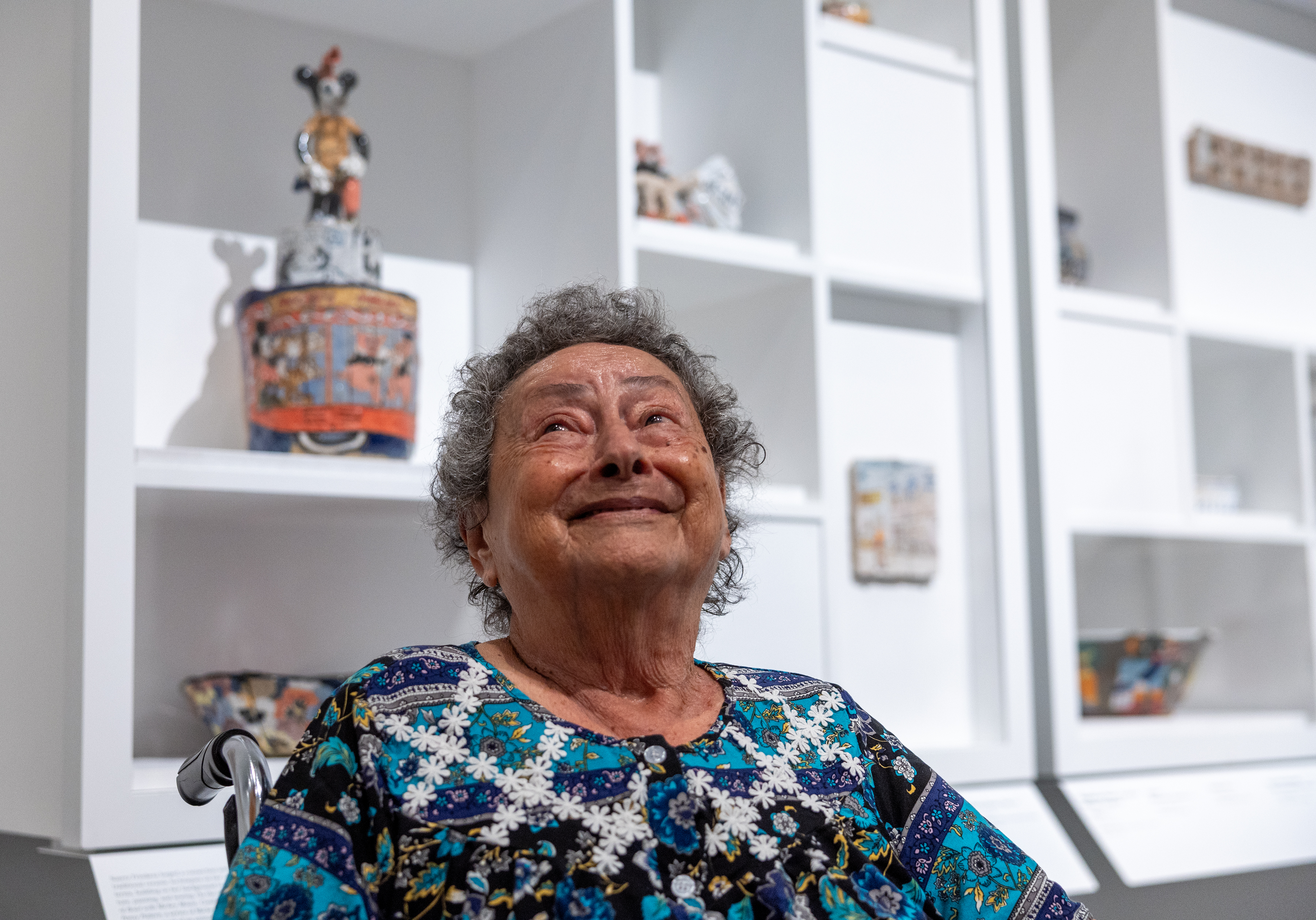 Artist Magdalena Suarez Frimkess, 95, looks up from her wheelchair with a big smile during a preview for her new LACMA show.