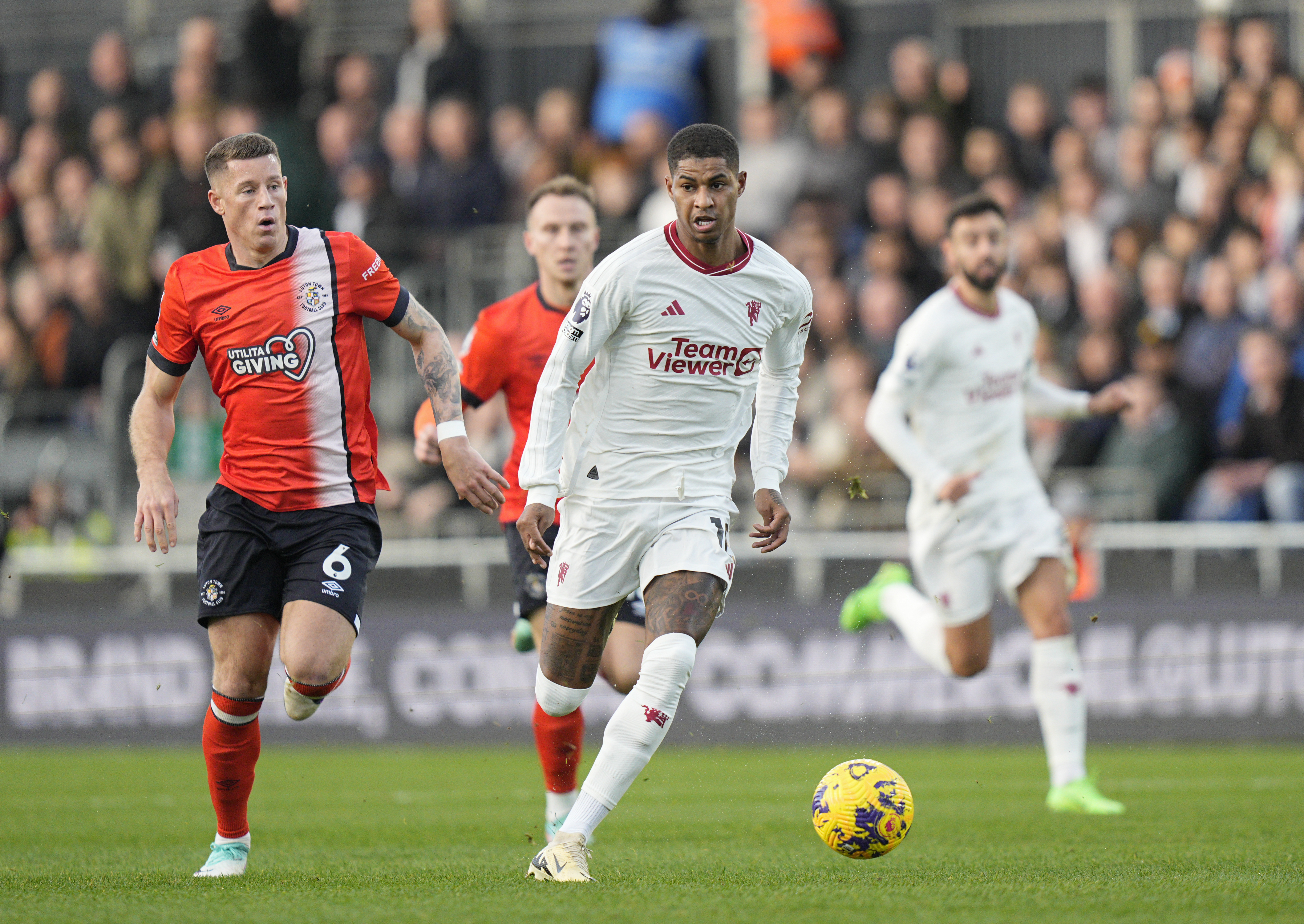 Manchester United's Marcus Rashford runs with the ball chased by Luton Town's Ross Barkley.