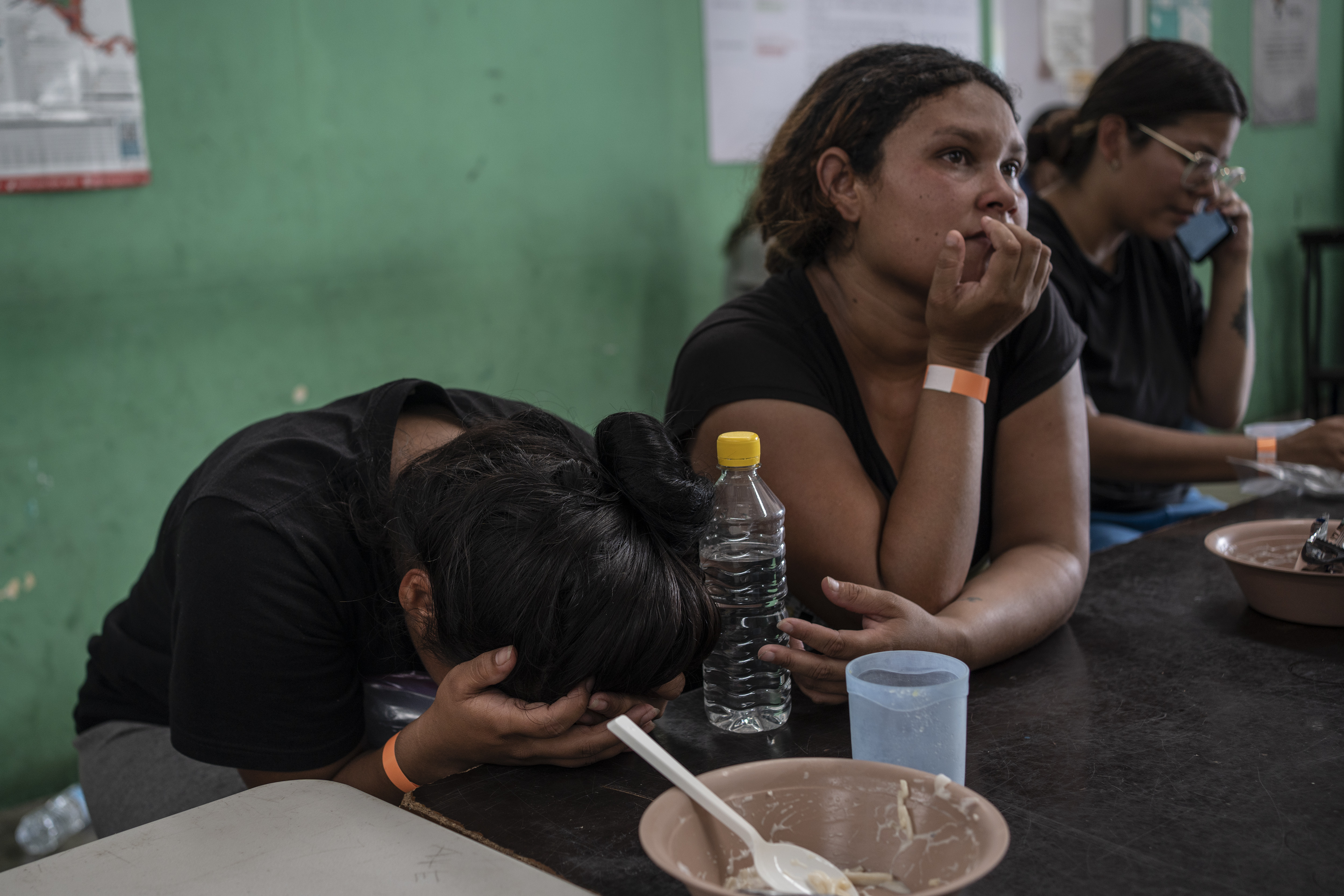 Yeneska Garcia, a Venezuelan migrant, cries into her hands as she eats at the Peace Oasis of the Holy Spirit Amparito shelter in Villahermosa, Mexico, Friday, June 7, 2024. Since the 23-year-old fled Venezuela in January, she trekked days through the jungles of The Darien Gap, narrowly survived being kidnapped by Mexican cartels and waited months for an asylum appointment with the U.S. that never came through. (AP Photo/Felix Marquez)